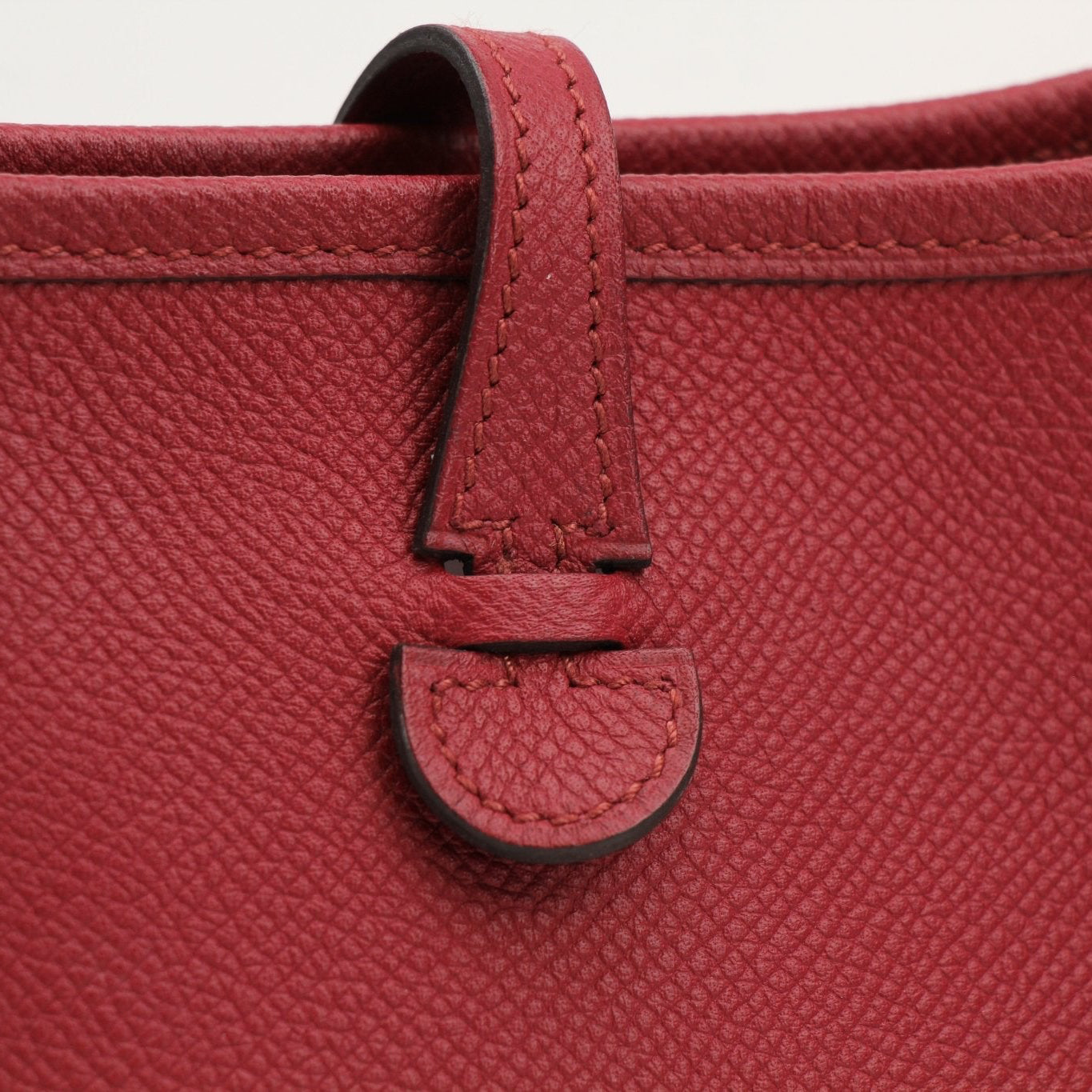 Hermès Evelyne Mini handbag in leather with gold hardware, featuring a shoulder strap and signature perforated design.