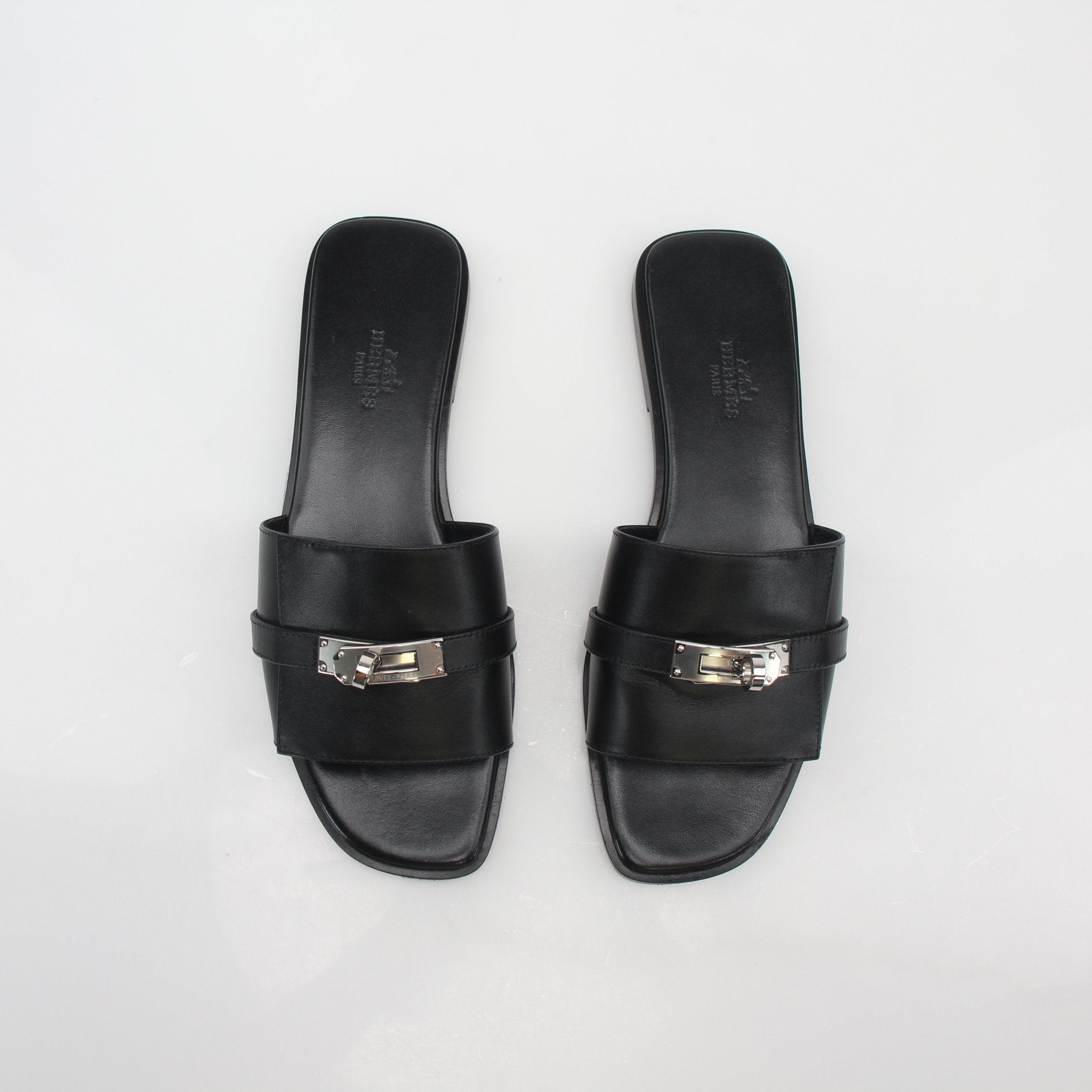 Hermès Black Gabriel leather slide sandals from Gold & Beyond, featuring sleek design and comfortable slip-on style.
