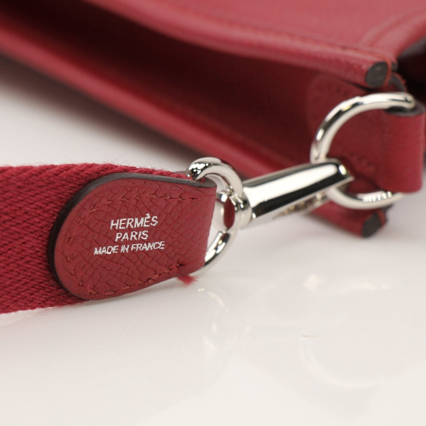 Hermès Evelyne Mini handbag in leather with gold accents, featuring adjustable strap and signature logo detail.