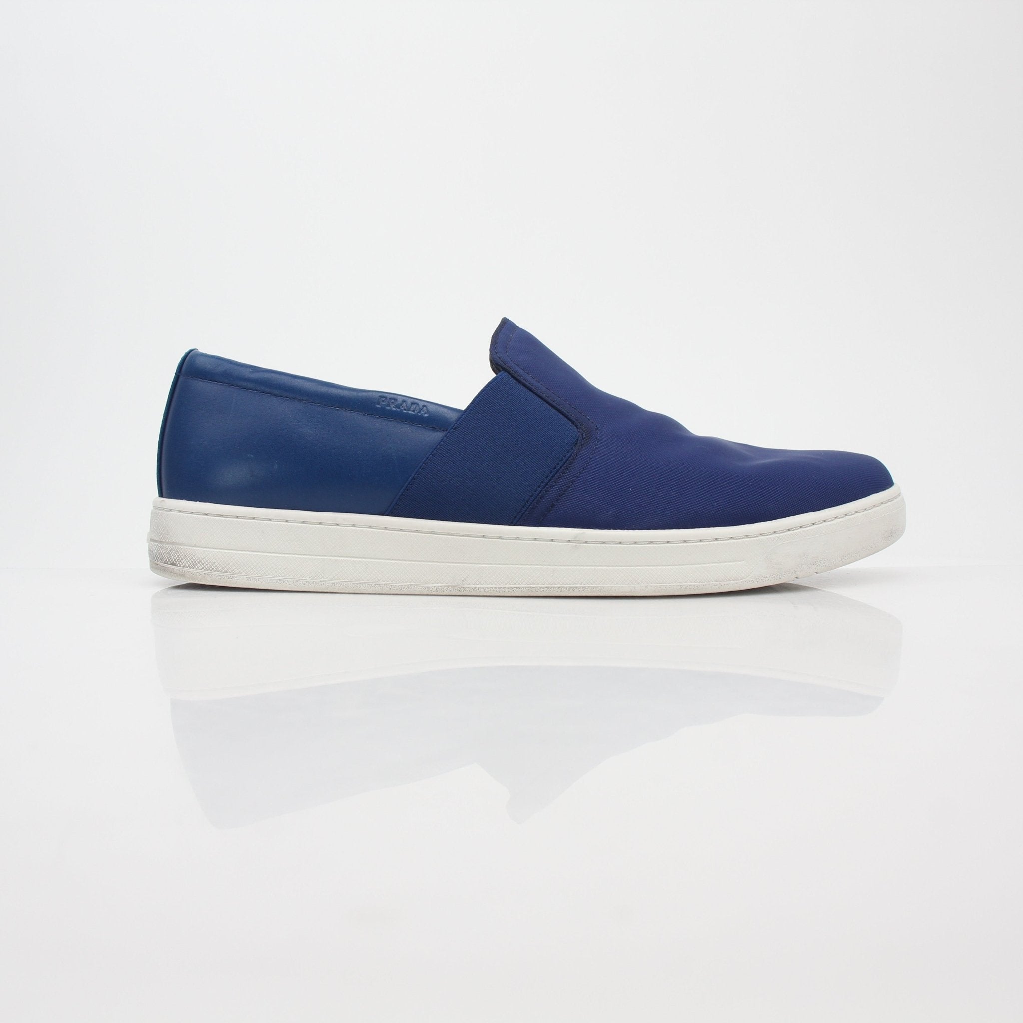 Prada blue nylon slip-on sneakers with white soles, showcasing sleek, lightweight shoe design and casual style.