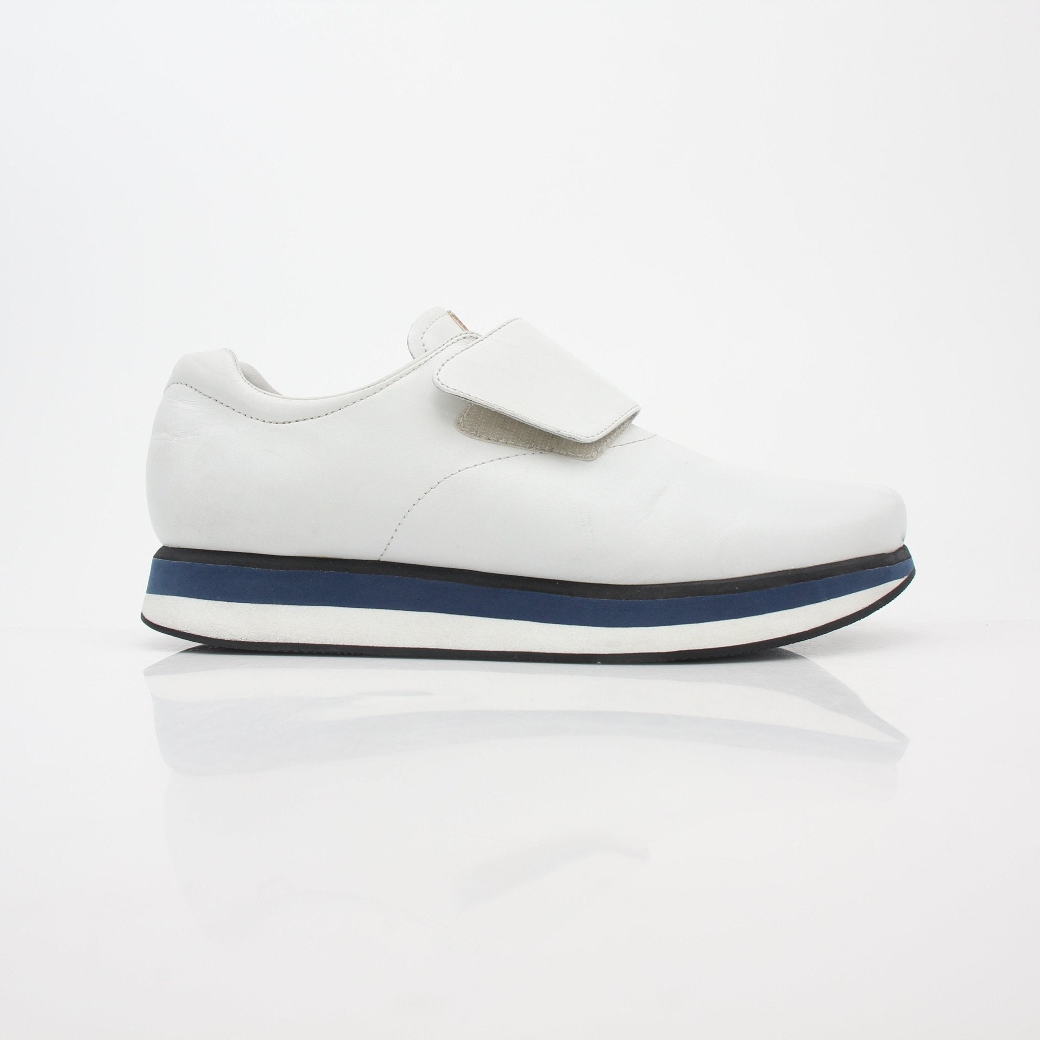 Prada white leather platform sneakers with chunky soles and clean design, featuring lace-up front and branding details.