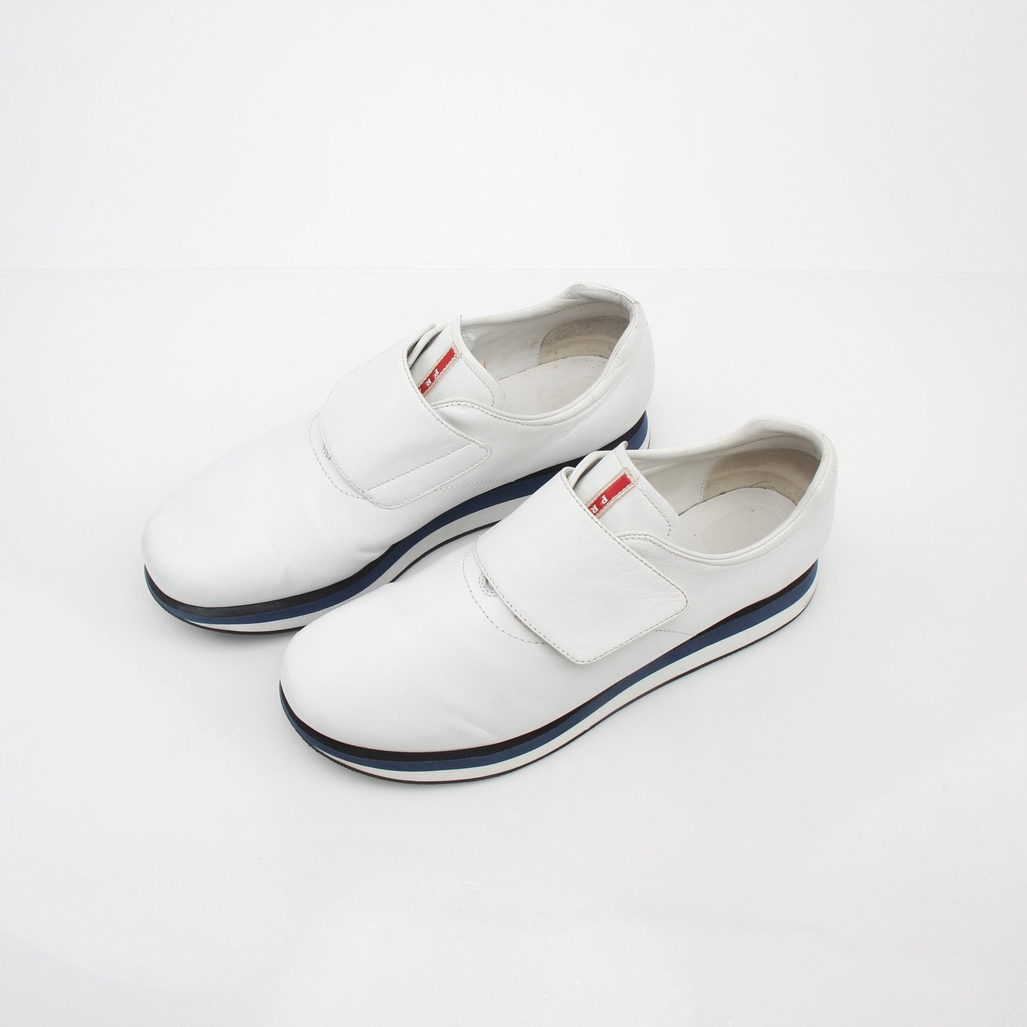 Prada white leather platform sneakers with chunky soles and stylish design, displayed on a plain background.