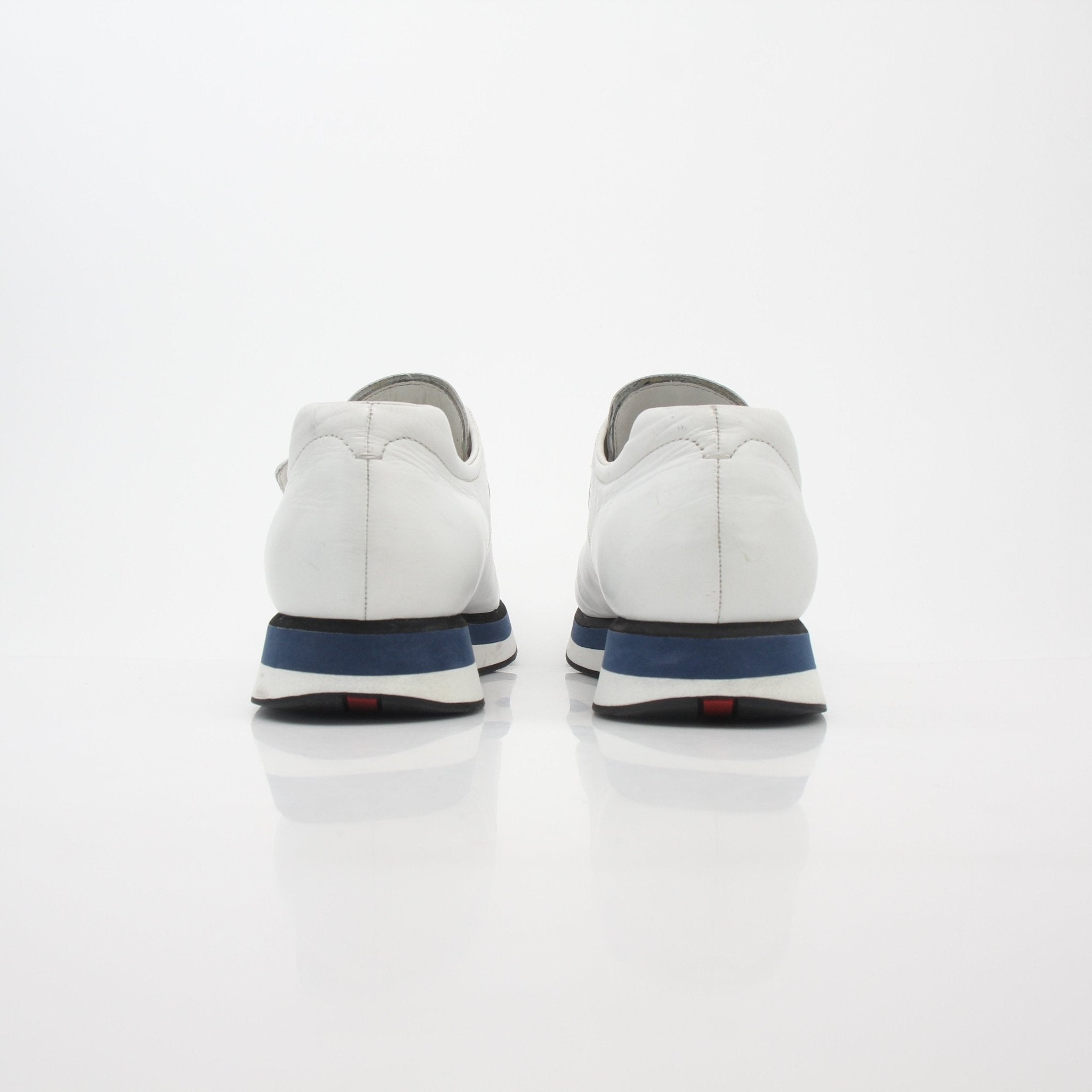Prada white leather platform sneakers with thick sole and lace-up design, shown on clean white background.