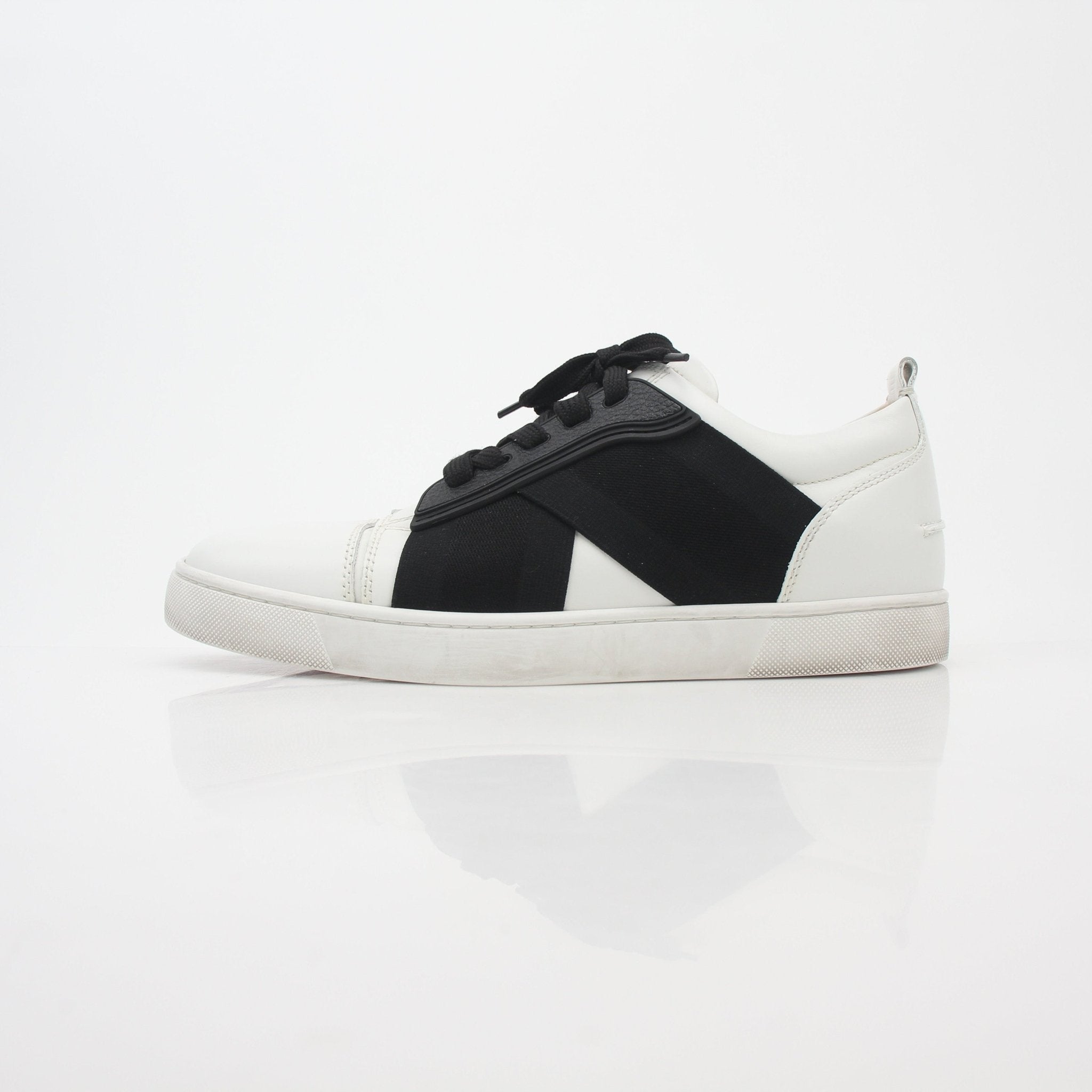 Christian Louboutin White and Black Elastikid Sneakers featuring sleek design and contrasting color details, worn on a casual setting.