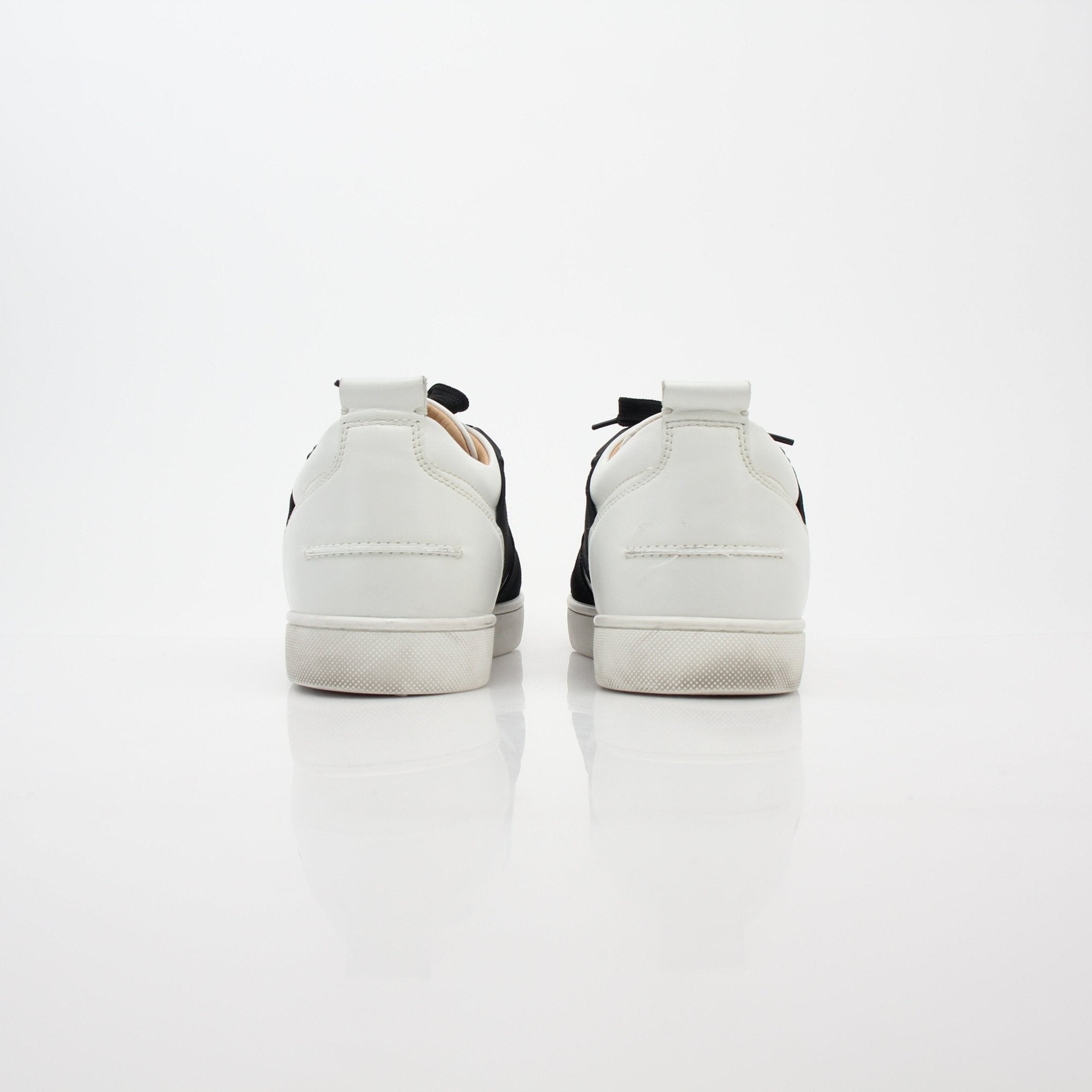 Christian Louboutin Elastikid sneakers in white and black with red soles, featuring sleek design and logo details.