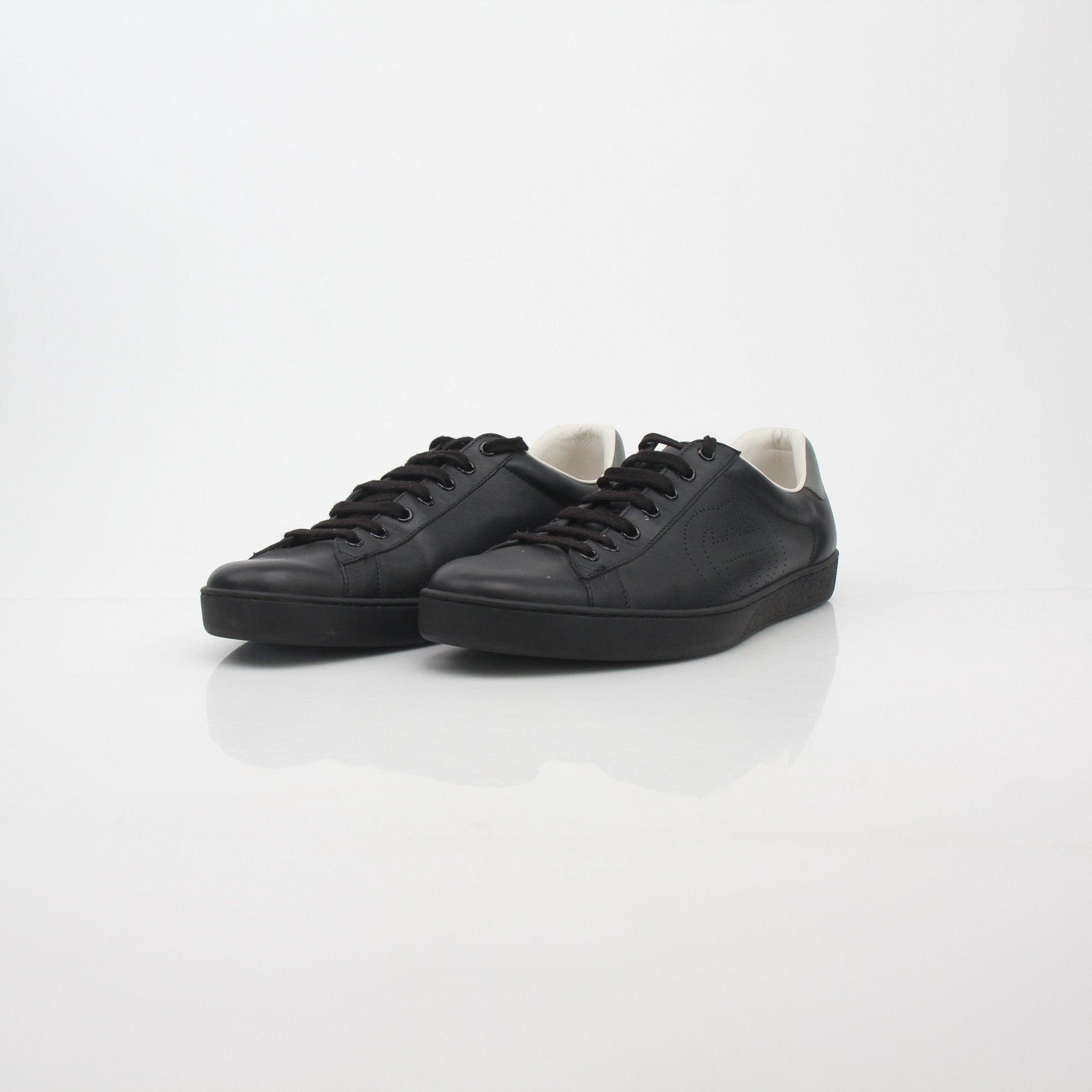 Black Gucci Ace sneakers with perforated leather and interlocking G logo, stylish shoes from Gold & Beyond.