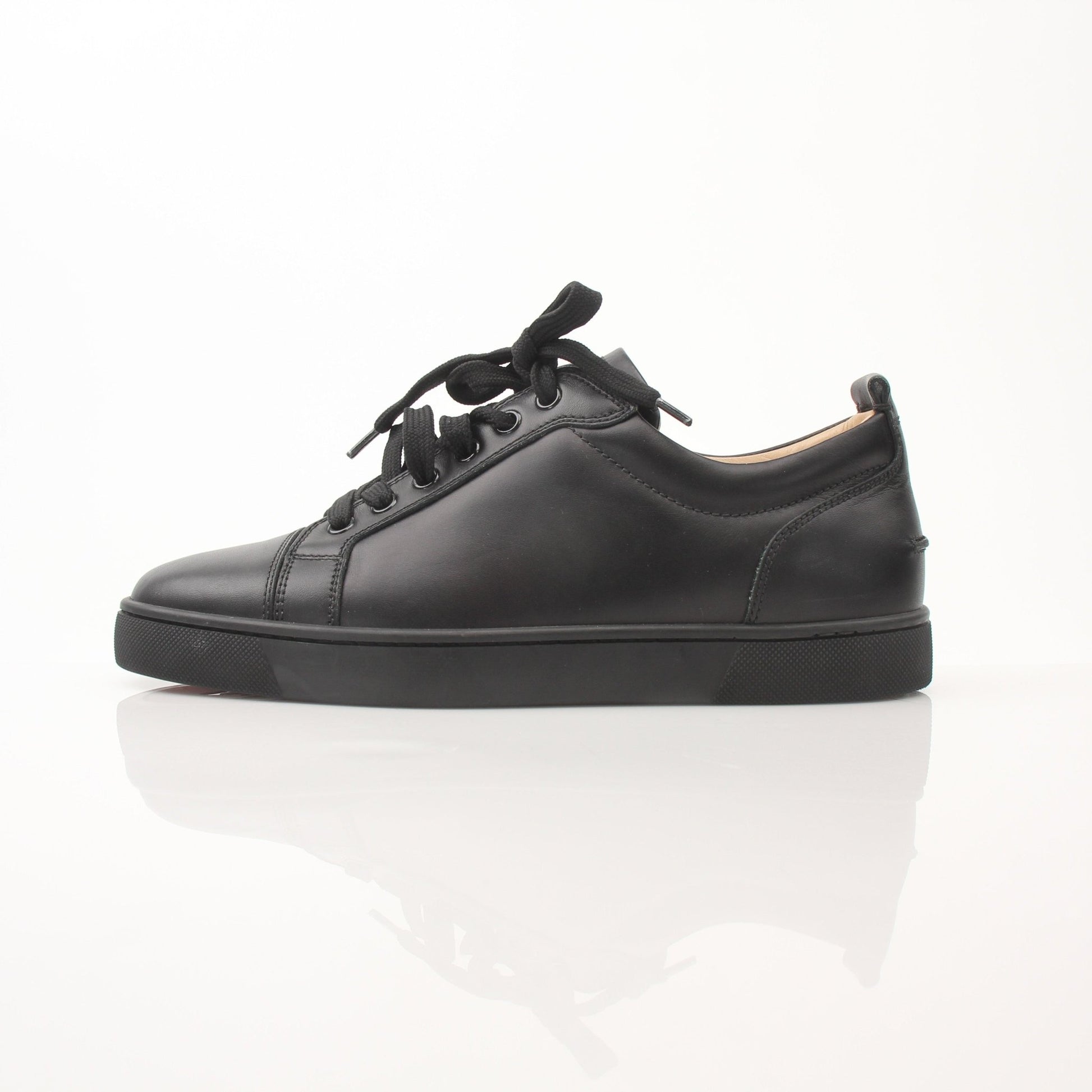Christian Louboutin Louis Junior sneakers in black with red soles, featuring luxurious leather and stylish design.