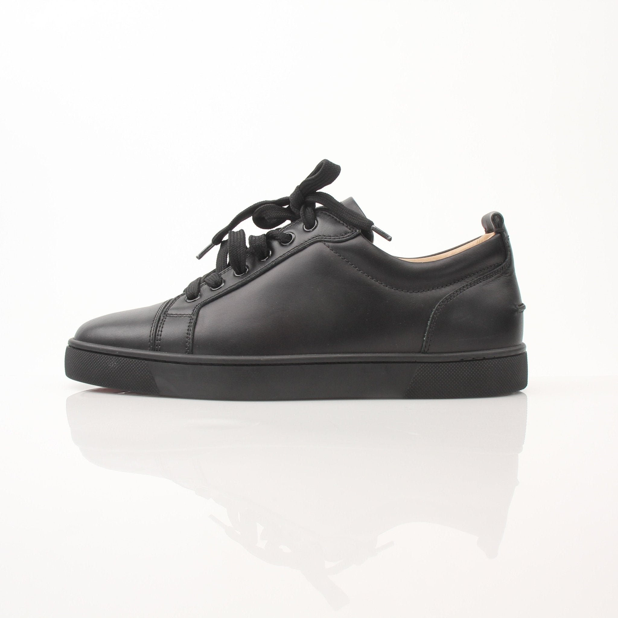 Christian Louboutin Louis Junior sneakers in black with red soles, featuring luxurious leather and stylish design.