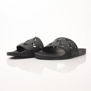 Gold & Beyond Gucci Pursuit Slides shoes featuring black straps and a sleek design, displayed on a plain background.