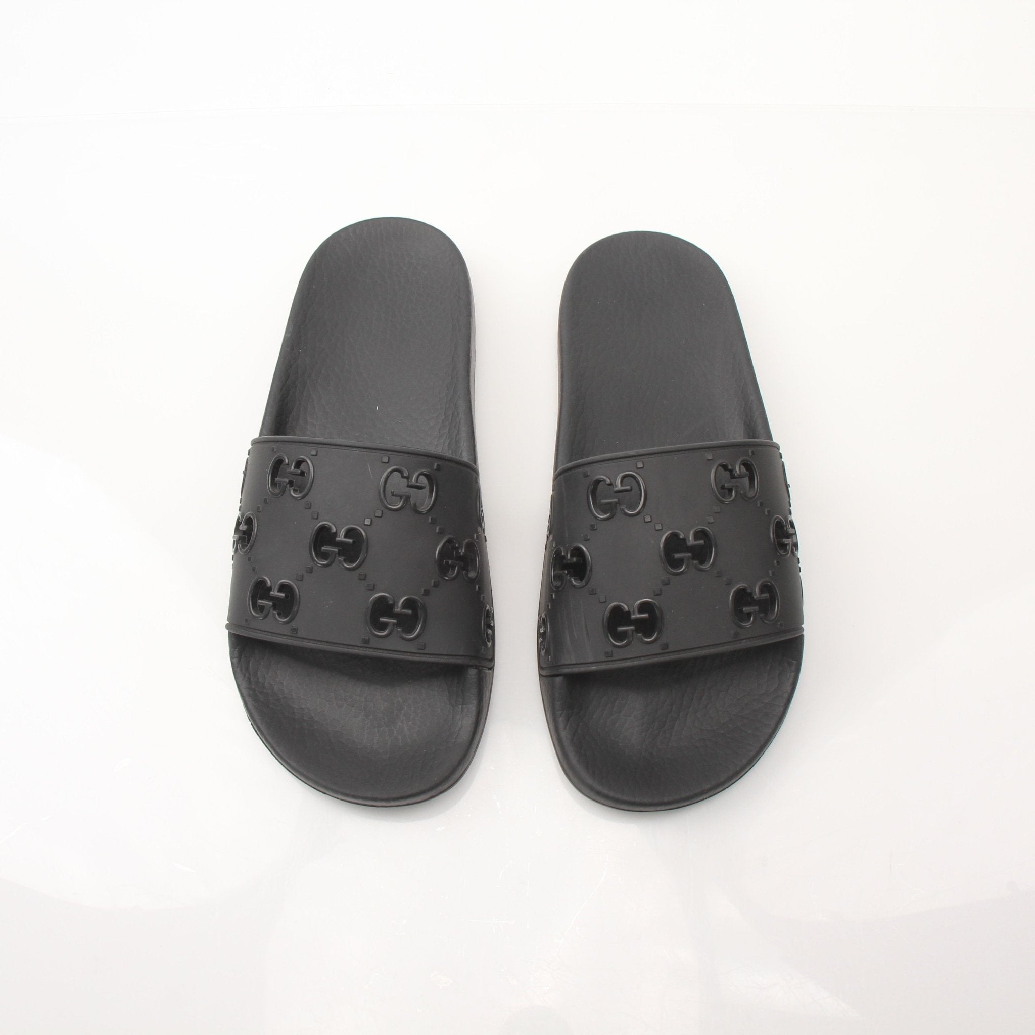 Gold & Beyond Gucci Pursuit Slides shoes with black straps and gold accents, casual slip-on footwear on a neutral background.