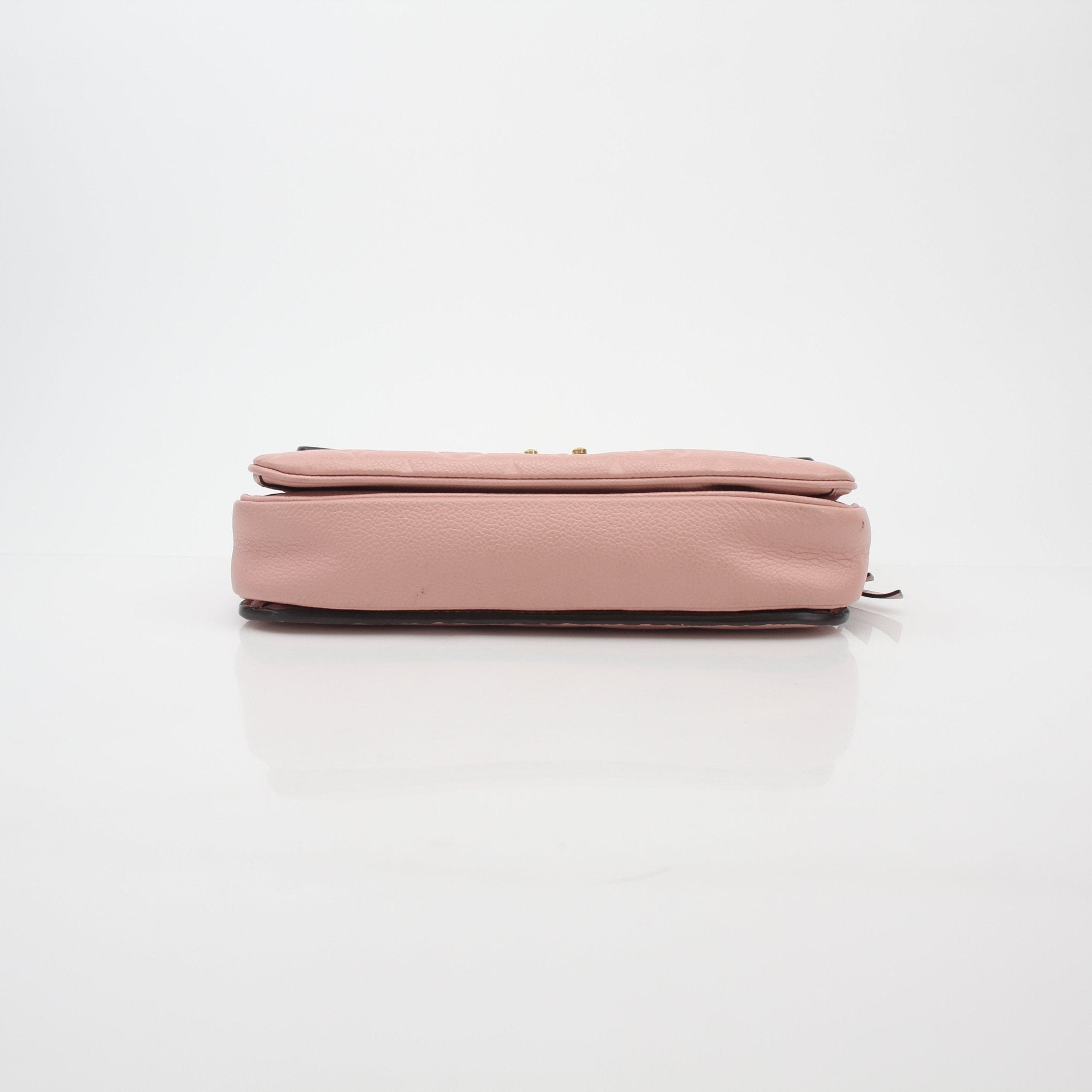 Louis Vuitton Rose Poudre Monogram Empreinte Pochette Métis shoulder handbag with gold hardware and leather strap, detailed monogram design.