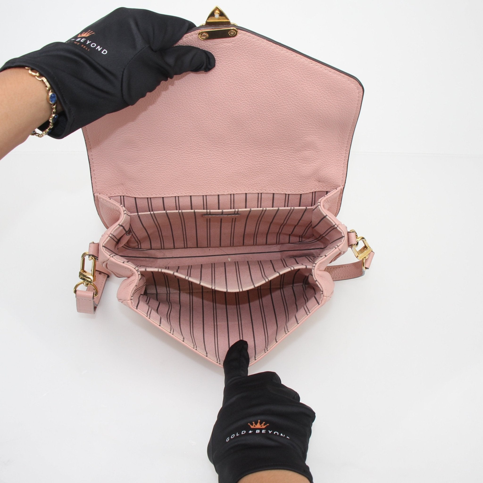 Louis Vuitton Rose Poudre Monogram Empreinte Pochette Métis shoulder handbag with gold accents and adjustable shoulder strap.