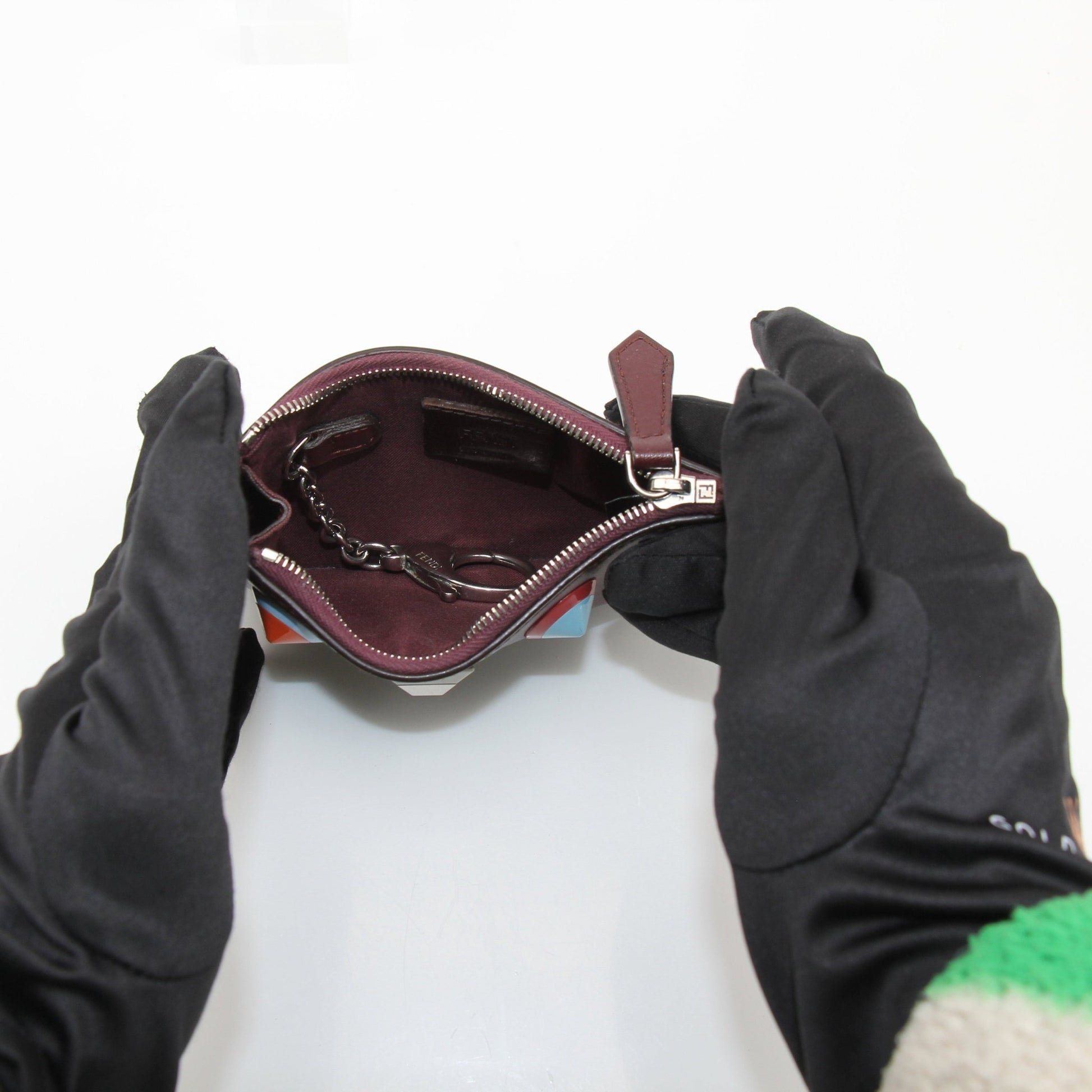 Purple Fendi keychain pouch wallet with gold hardware and compact design, displayed on a white background.