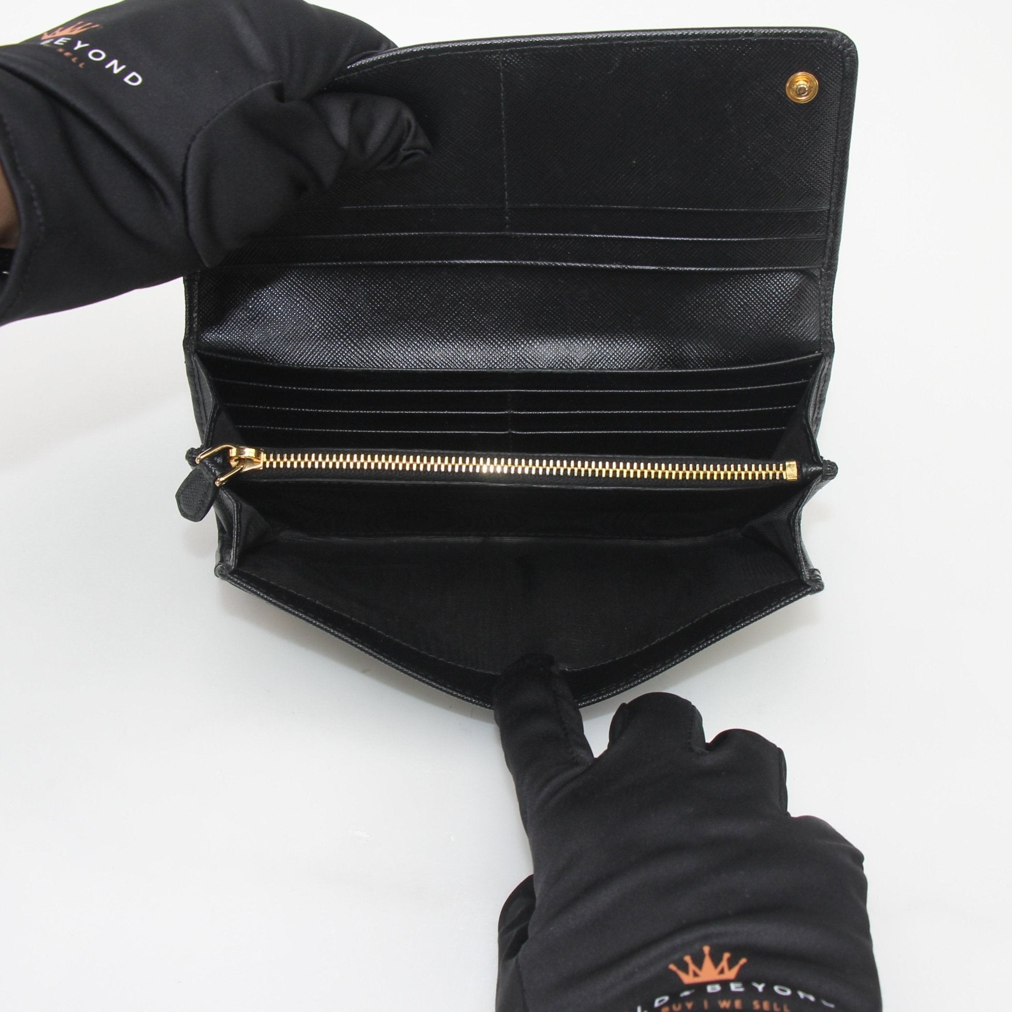 Prada black saffiano leather continental wallet with gold hardware, featuring multiple card slots and a sleek, structured design.