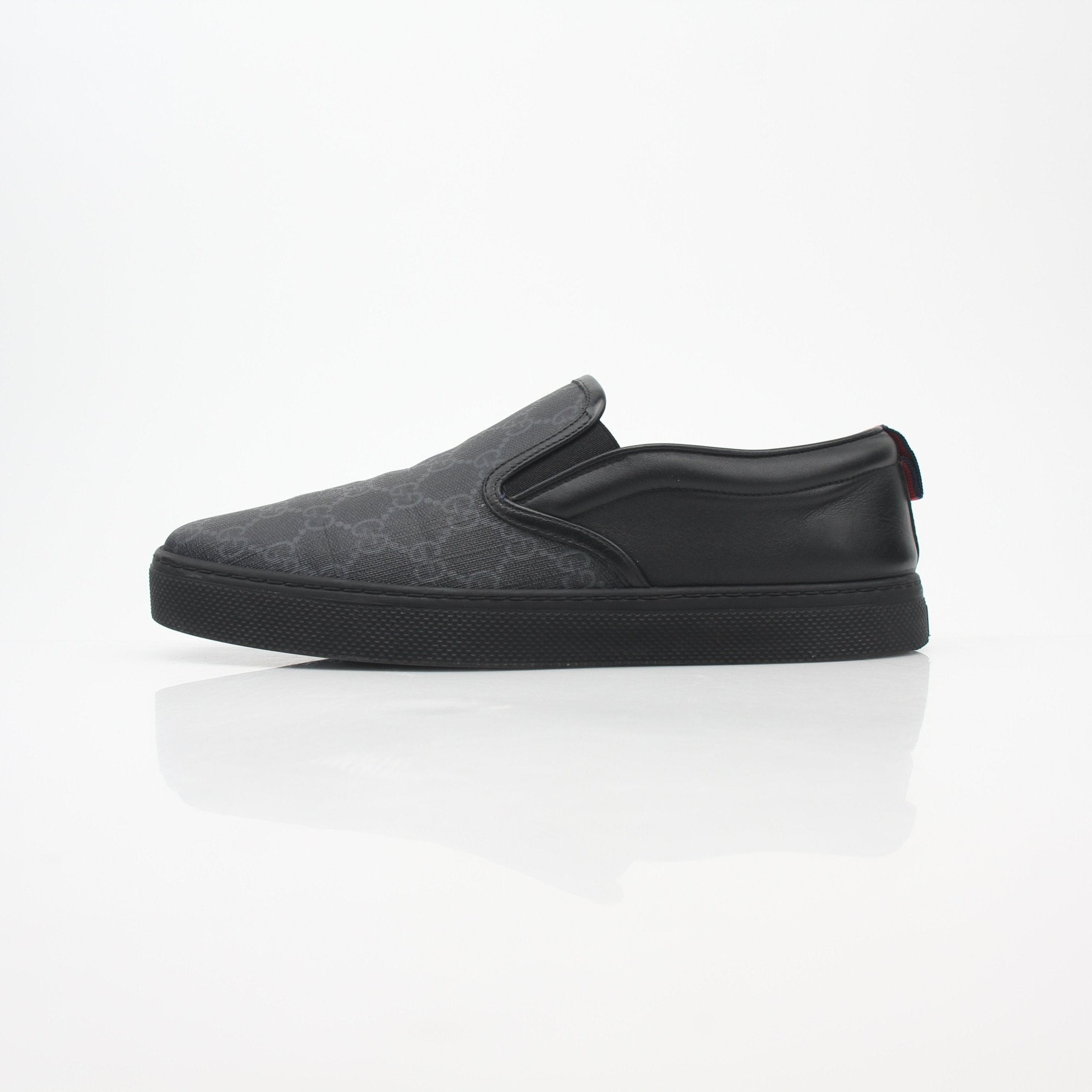 Gucci Black GG Supreme Dublin slip-on sneakers with white soles and logo detailing, styled on a plain background.