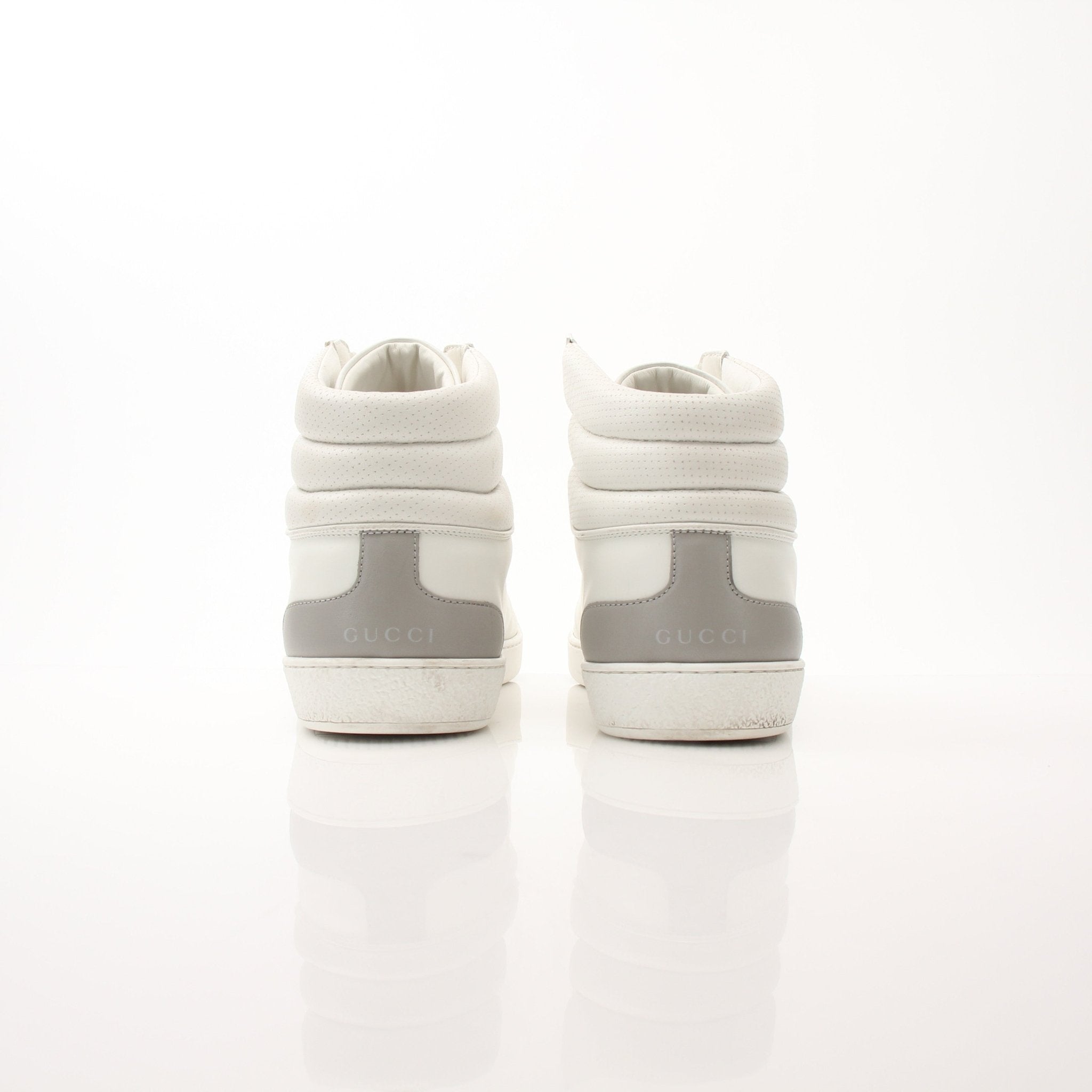 Gold & Beyond Gucci Ace high top sneakers showing white canvas with Gucci logo details and rubber sole.