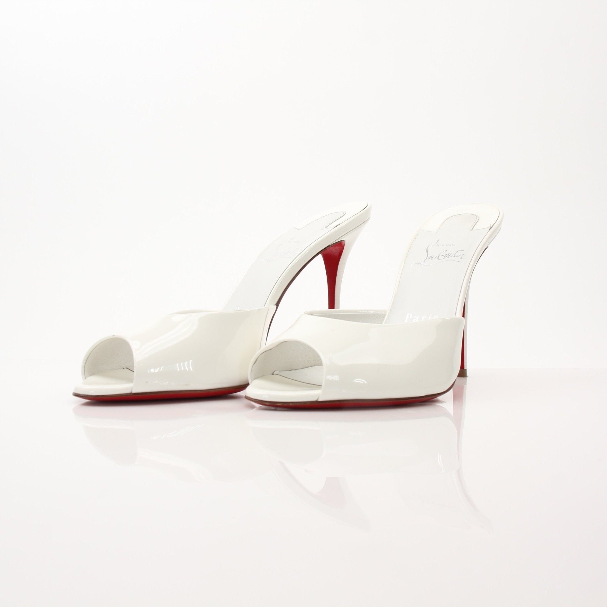 Christian Louboutin White Me Dolly Mules shoes with pointed toes and sleek design, displayed on a neutral background.