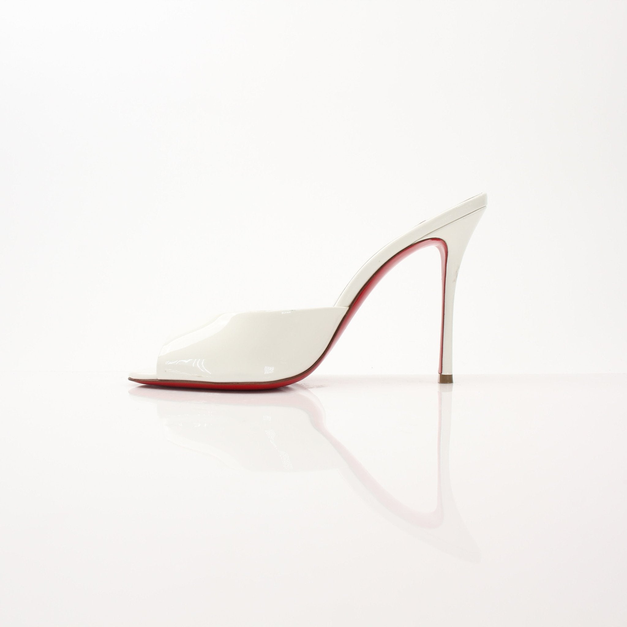 Christian Louboutin White Me Dolly Mules shoes with pointed toes and signature red soles, stylishly displayed on a neutral background.
