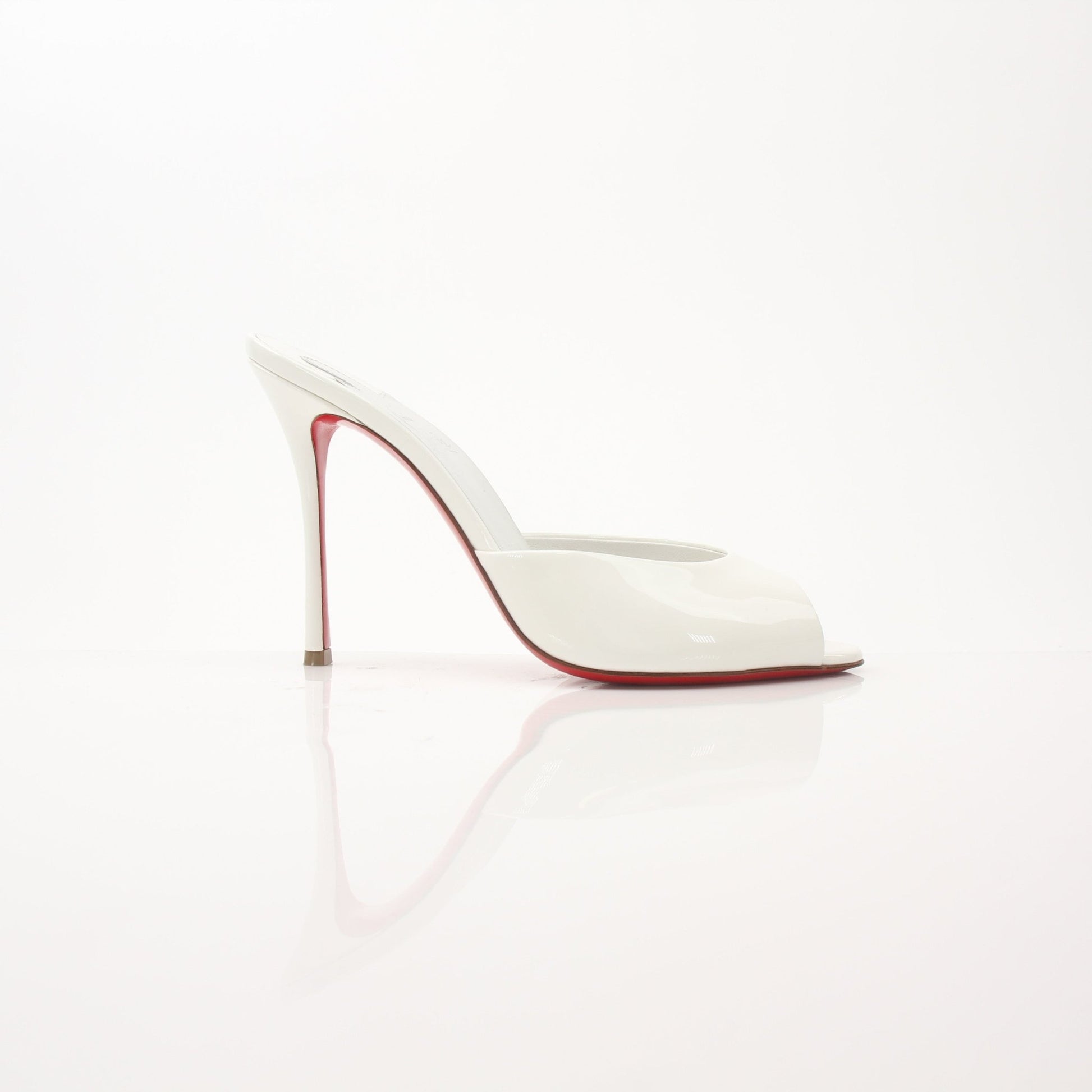 Christian Louboutin White Me Dolly Mules, stylish shoes with pointed toes and signature red soles, displayed on a neutral background.