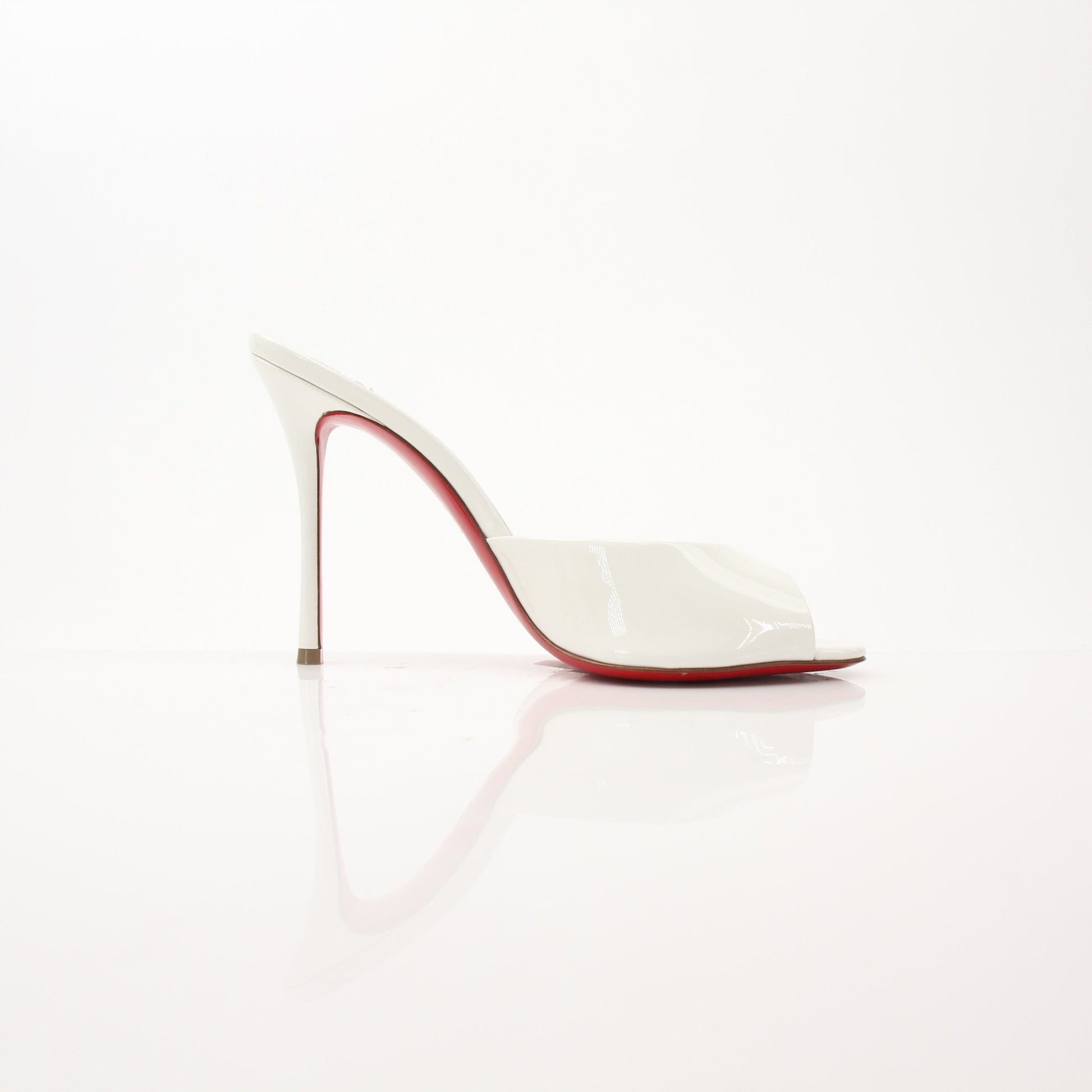 Christian Louboutin white Me Dolly mules shoes with pointed toes and signature red soles, displayed on a neutral background.