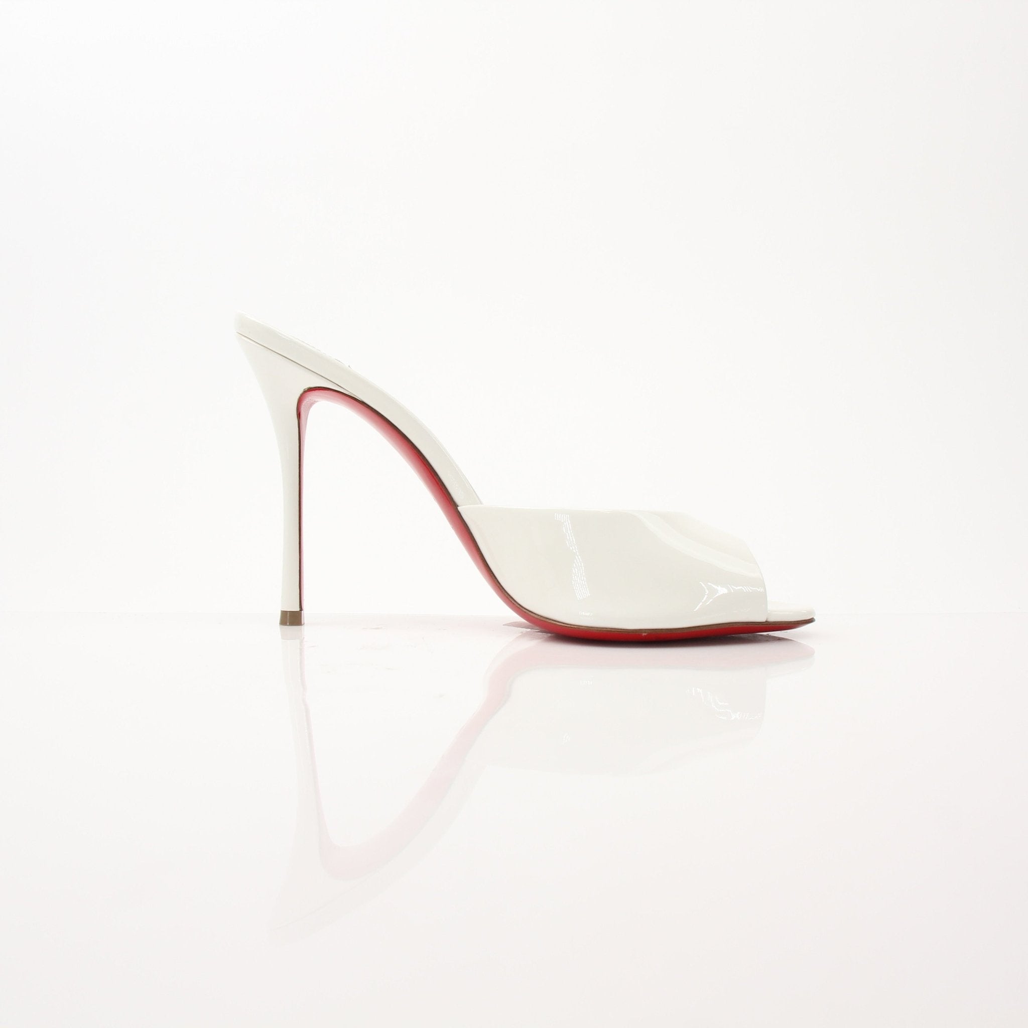 Christian Louboutin white Me Dolly mules shoes with pointed toes and signature red soles, displayed on a neutral background.