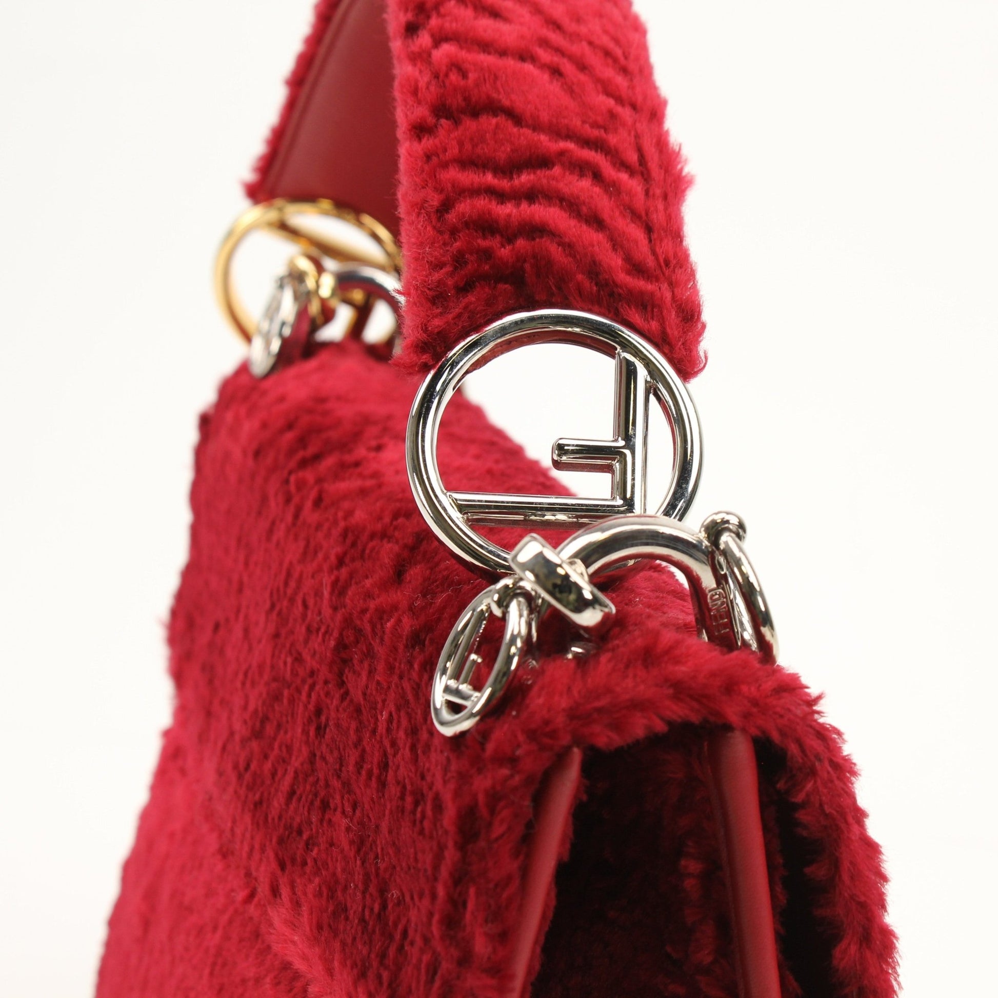 Fendi Kan I F velvet shoulder handbag with gold-tone hardware and sleek design, shown in a close-up image.