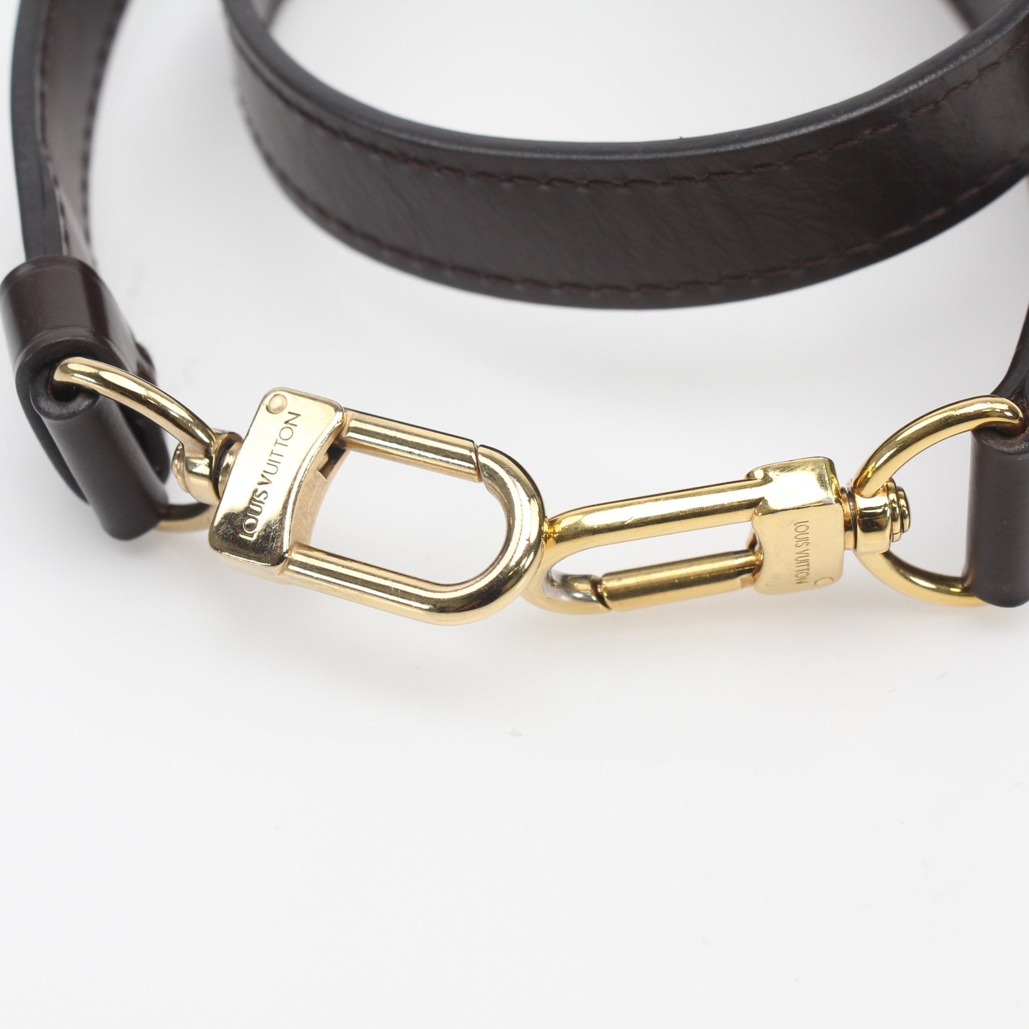 Brown leather adjustable shoulder strap for Louis Vuitton accessories, featuring gold hardware and detailed stitching.