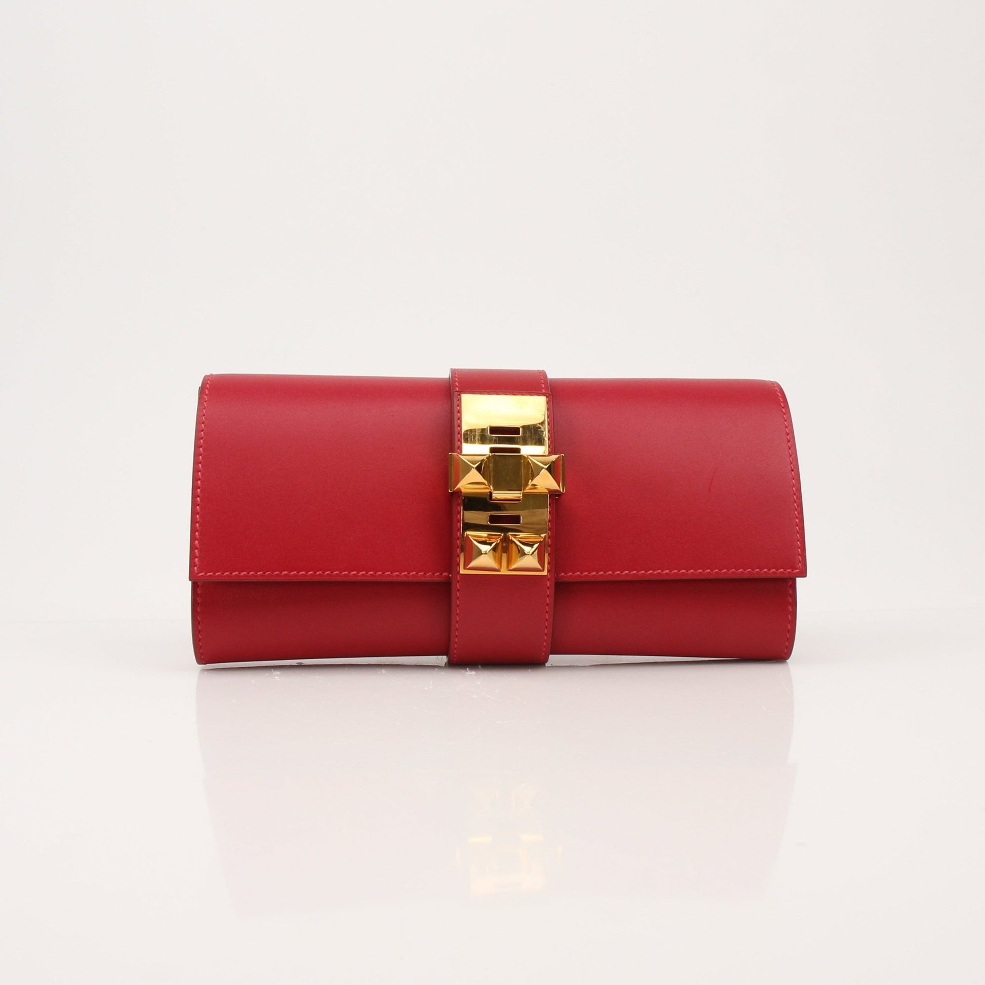Hermès Médor 23 red clutch handbag by Gold & Beyond, featuring sleek design and gold-tone hardware.