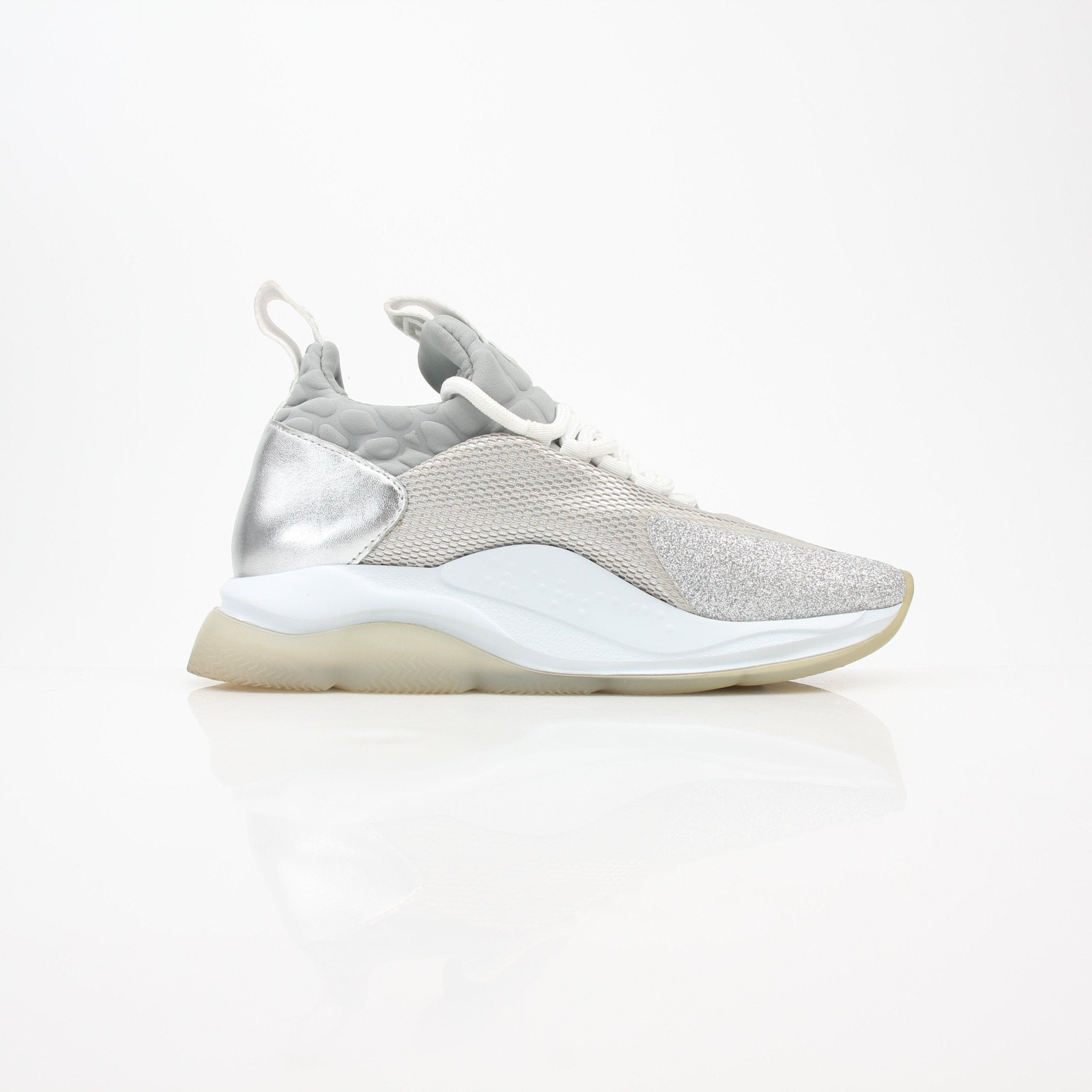 Versace Silver Chain Reaction low-top sneakers with metallic finish and stylish design, worn on a model's feet.
