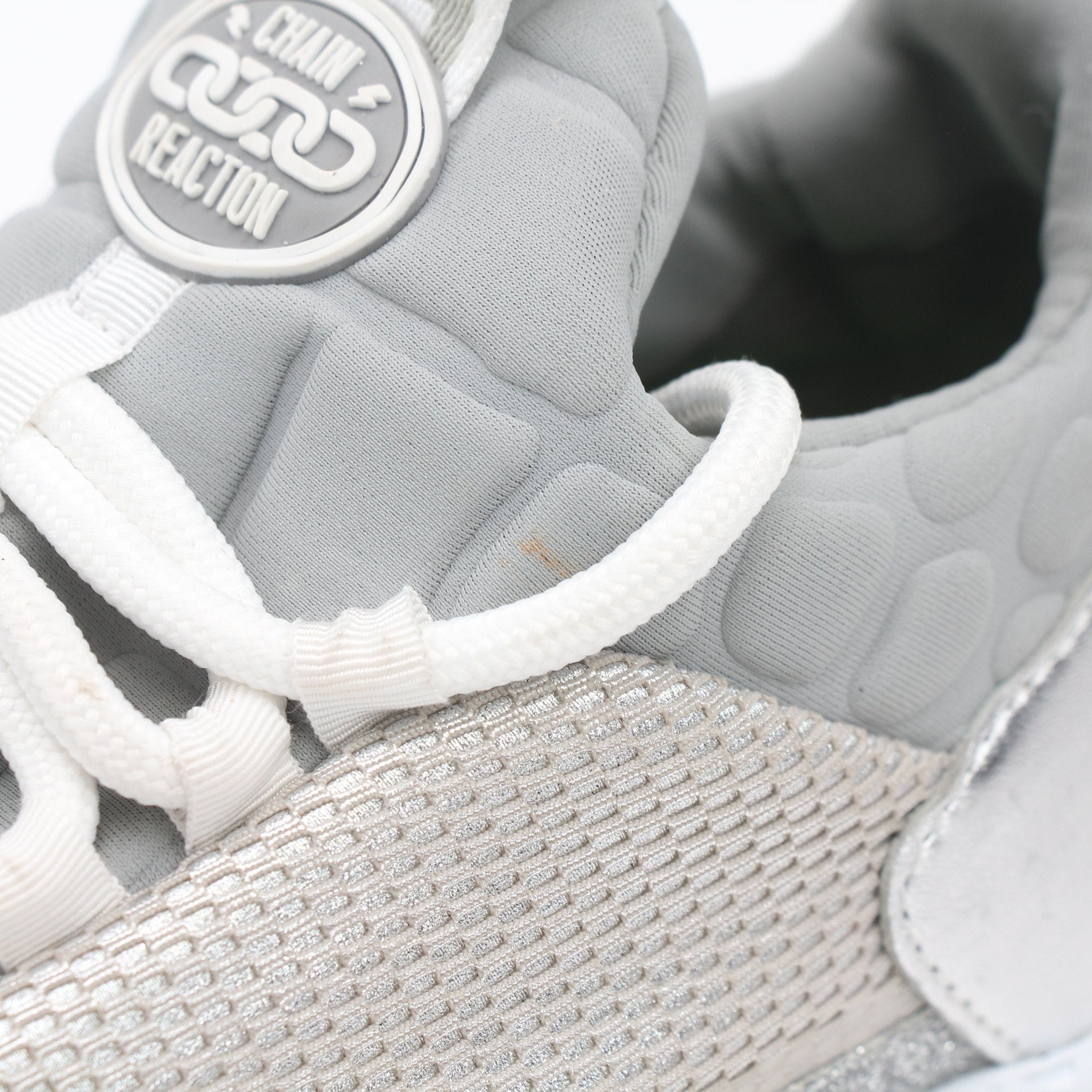Versace Silver Chain Reaction low-top sneakers with metallic accents and stylish design, displayed on a white background.