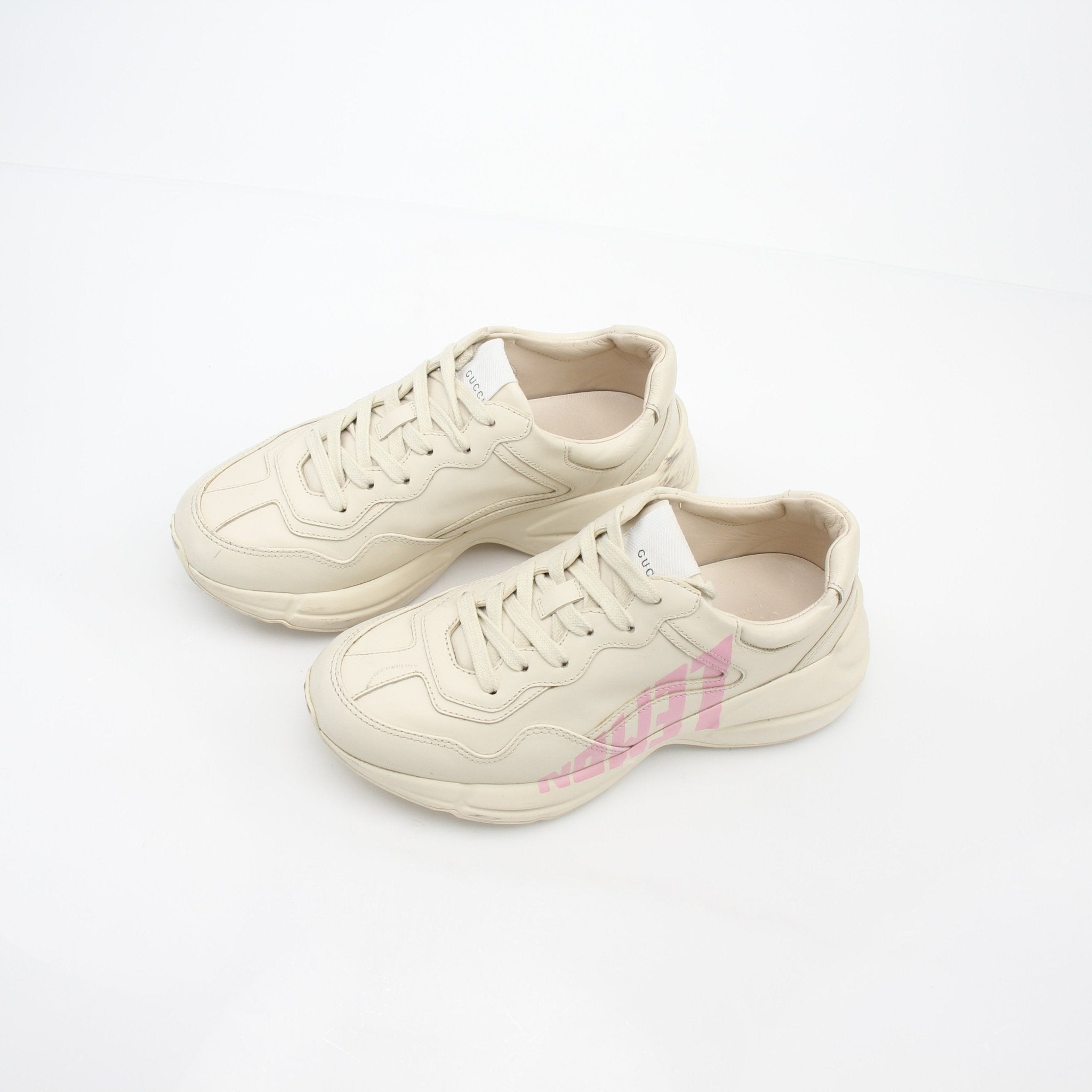 Gucci ivory Rhyton Lemon low-top sneakers with branding and stylish design, worn on a model's feet.