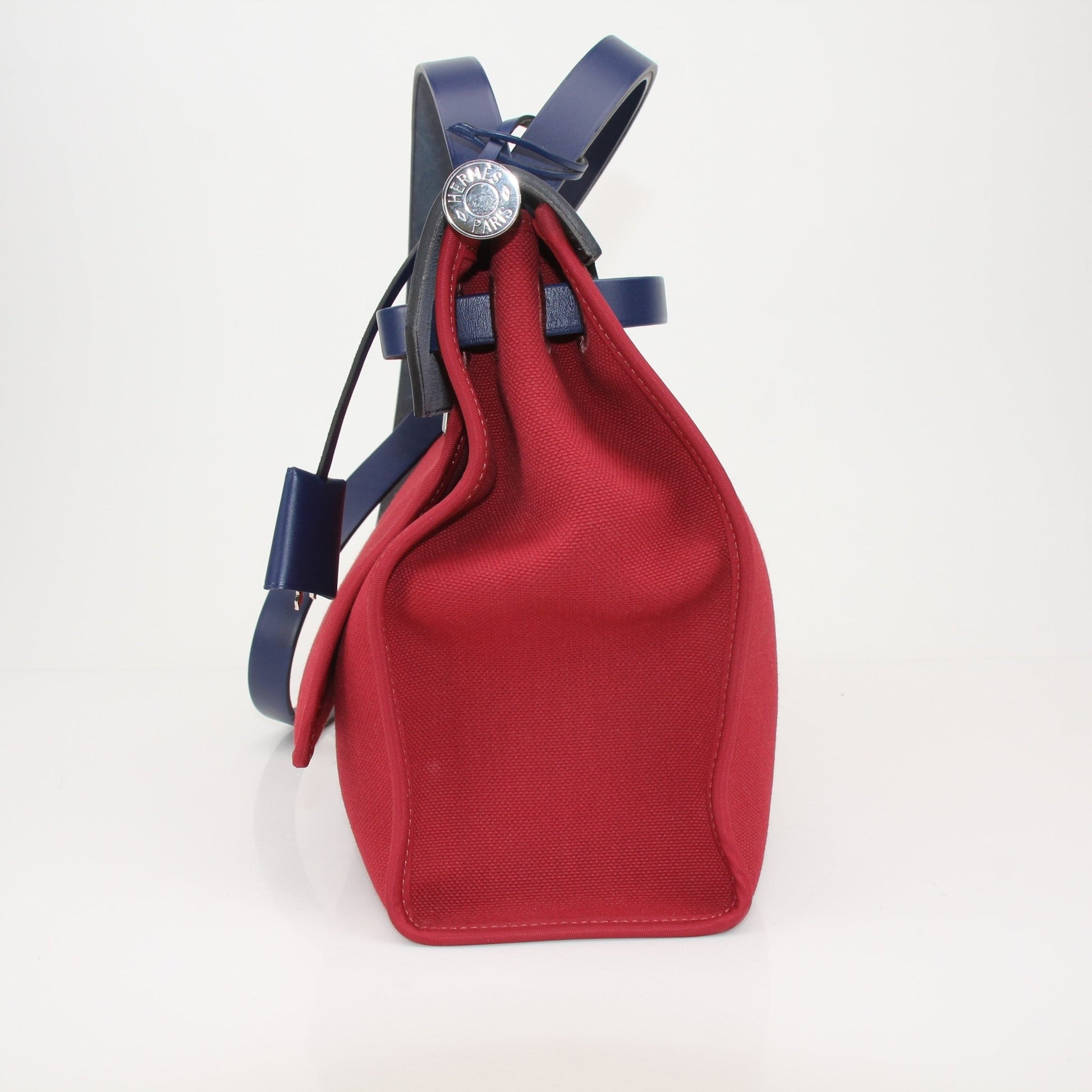 Hermès Herbag handbag with leather handles and canvas body, featuring classic design and neutral tones.