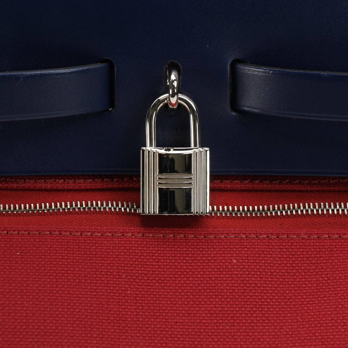 Hermès Herbag handbag with leather straps and canvas body, featuring gold hardware details.