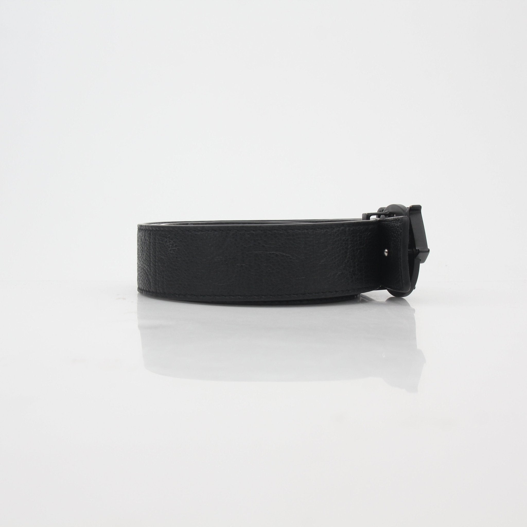 Christian Dior black leather belt with signature buckle, stylish accessory featuring Dior branding and gold-tone hardware.