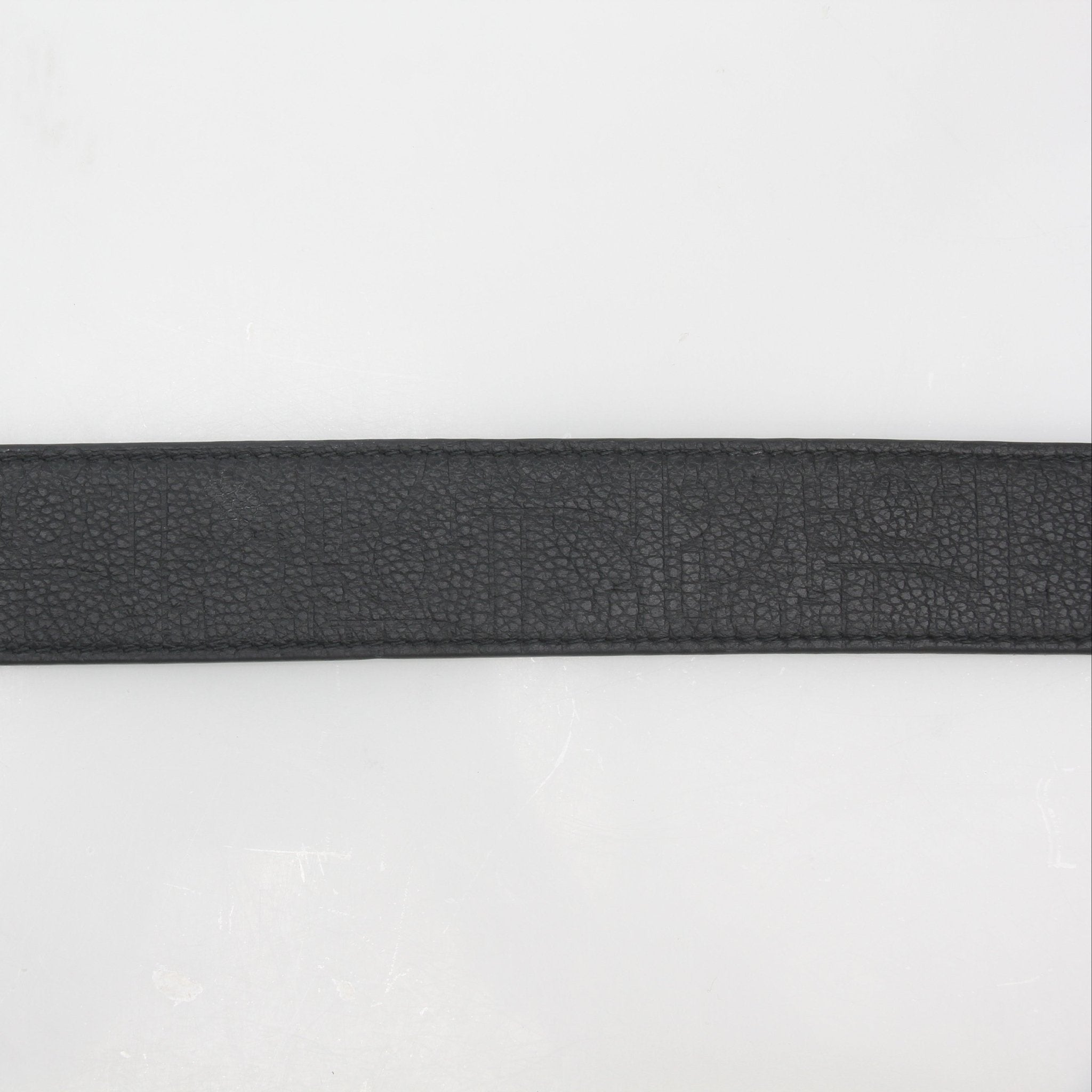 Black leather Christian Dior signature buckle belt with gold accents, showcasing the Dior logo and sleek design.