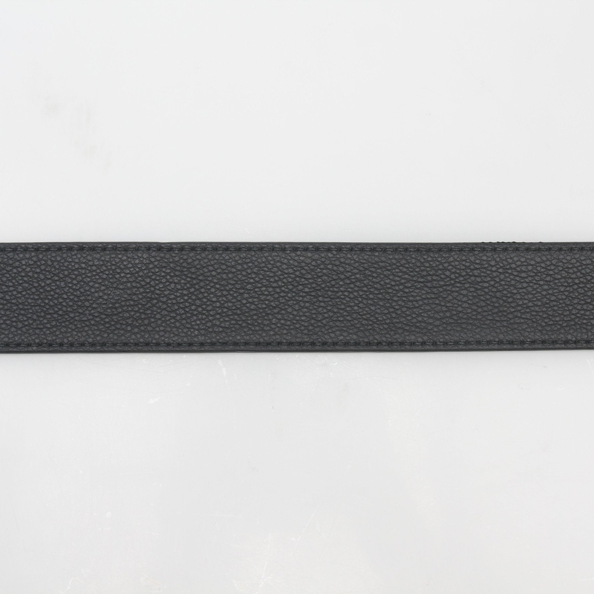Black leather Christian Dior signature buckle belt, stylish accessories with gold accents, displayed on a neutral background.
