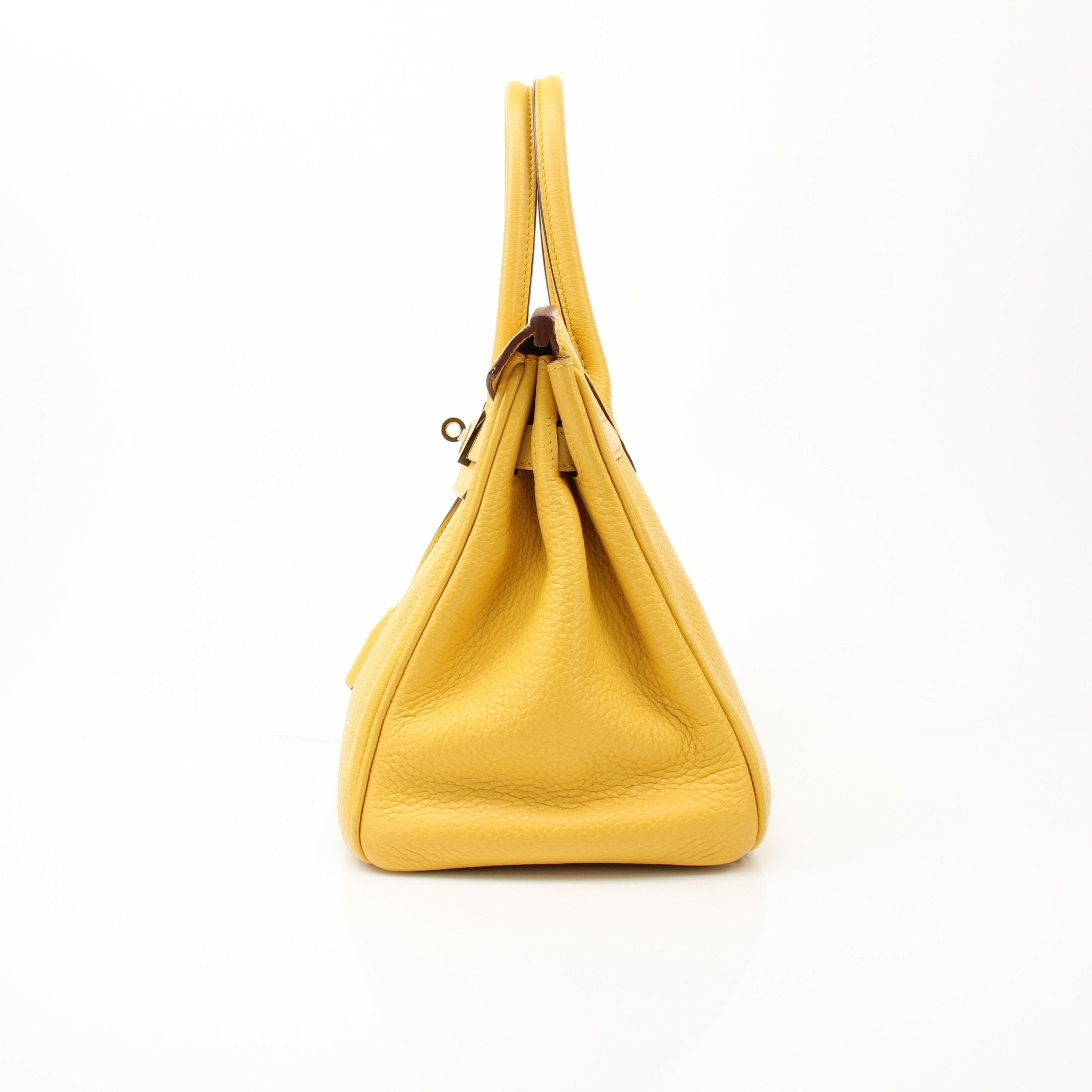 Yellow Hermès Birkin 30 handbag with gold hardware, shown from a side angle with handles and textured leather visible.