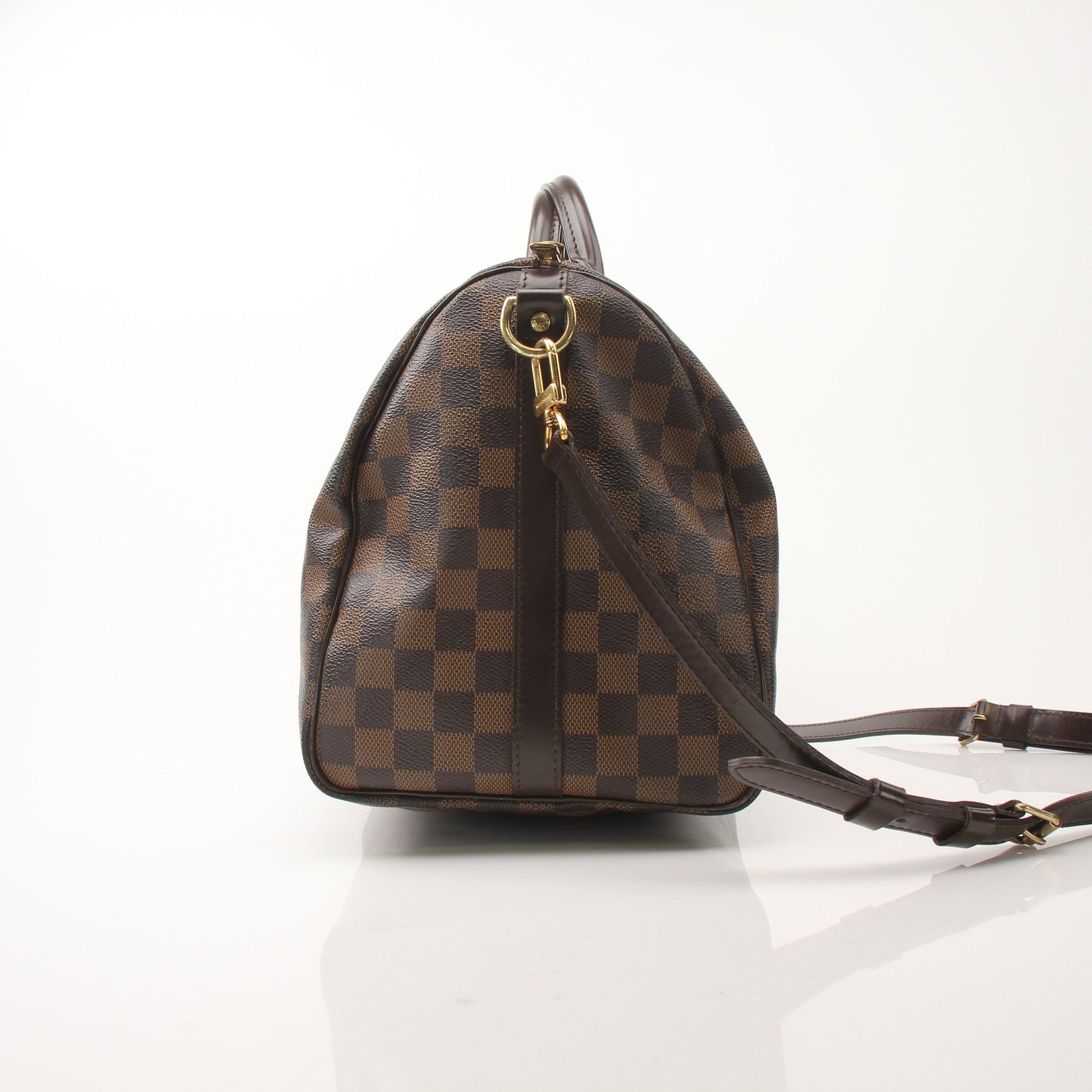 Gold & Beyond Louis Vuitton Speedy Bandouliere 35 shoes with stylish design and luxury branding, displayed on a white background.