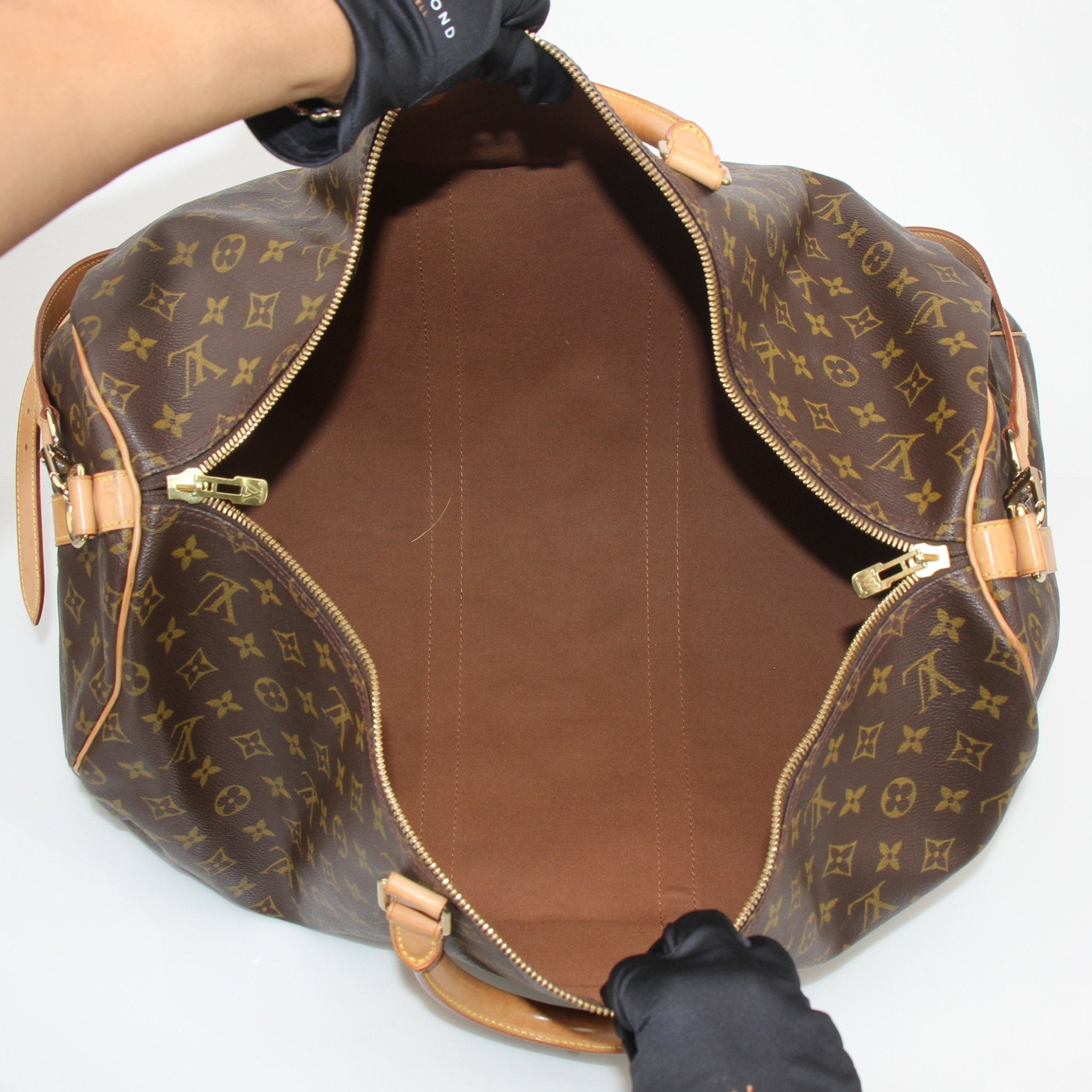 Louis Vuitton Monogram Keepall Bandoulière 55 duffle bag with leather handles and gold hardware, ideal for travel.