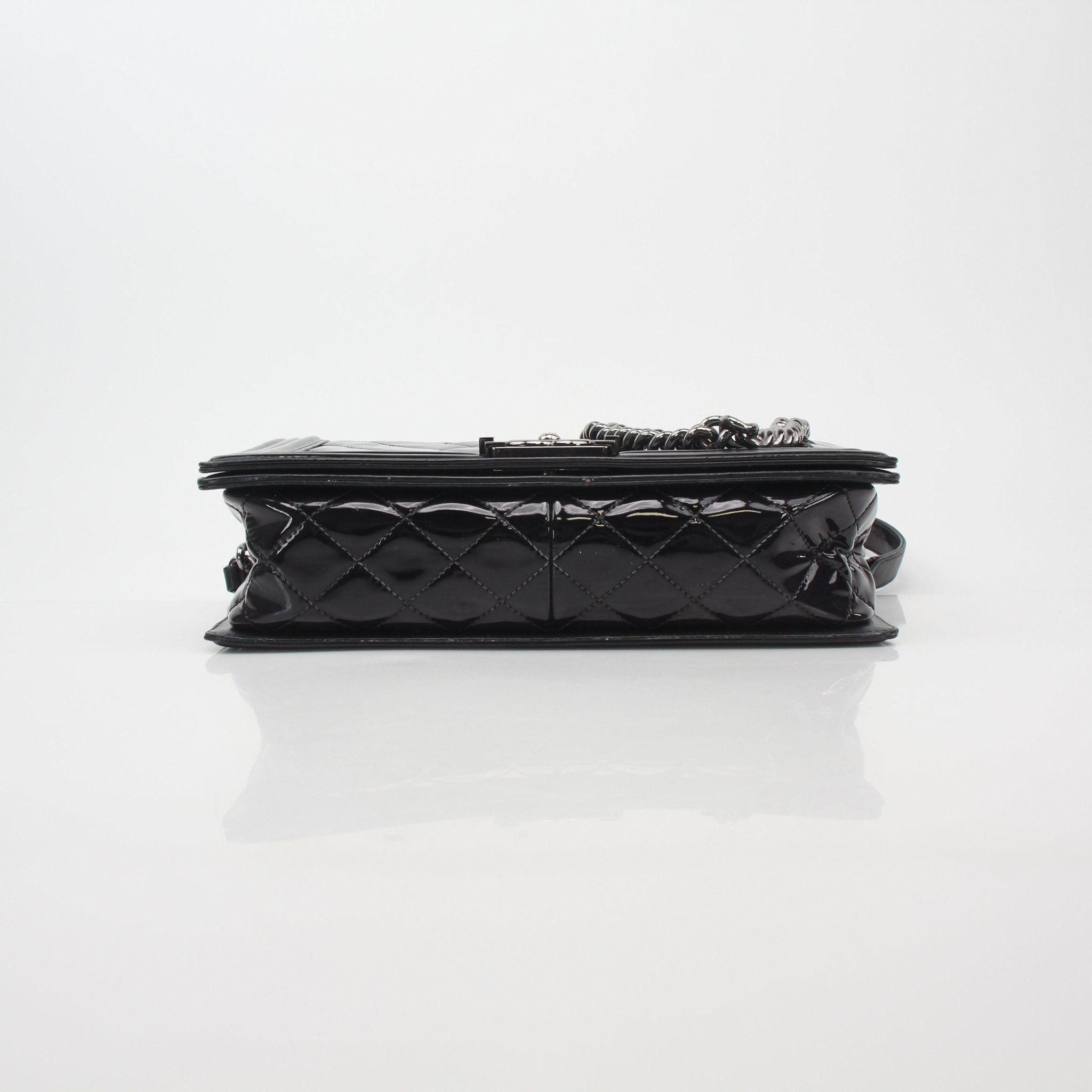 Gold & Beyond black quilted patent leather Chanel Boy Flap Bag handbag with gold hardware and signature quilting detail.