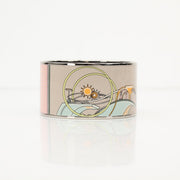 Hermès enamel cuff bracelet featuring colorful enamel inlay and sleek gold-tone jewelry design by Gold & Beyond.