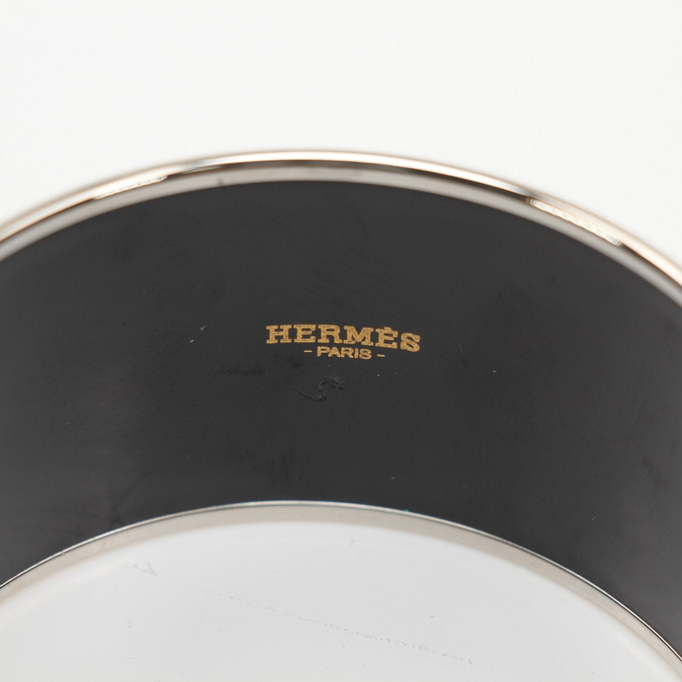 Hermès enamel cuff bracelet featuring colorful enamel inlay and gold-tone jewelry design, stylish accessory for elegant wear.