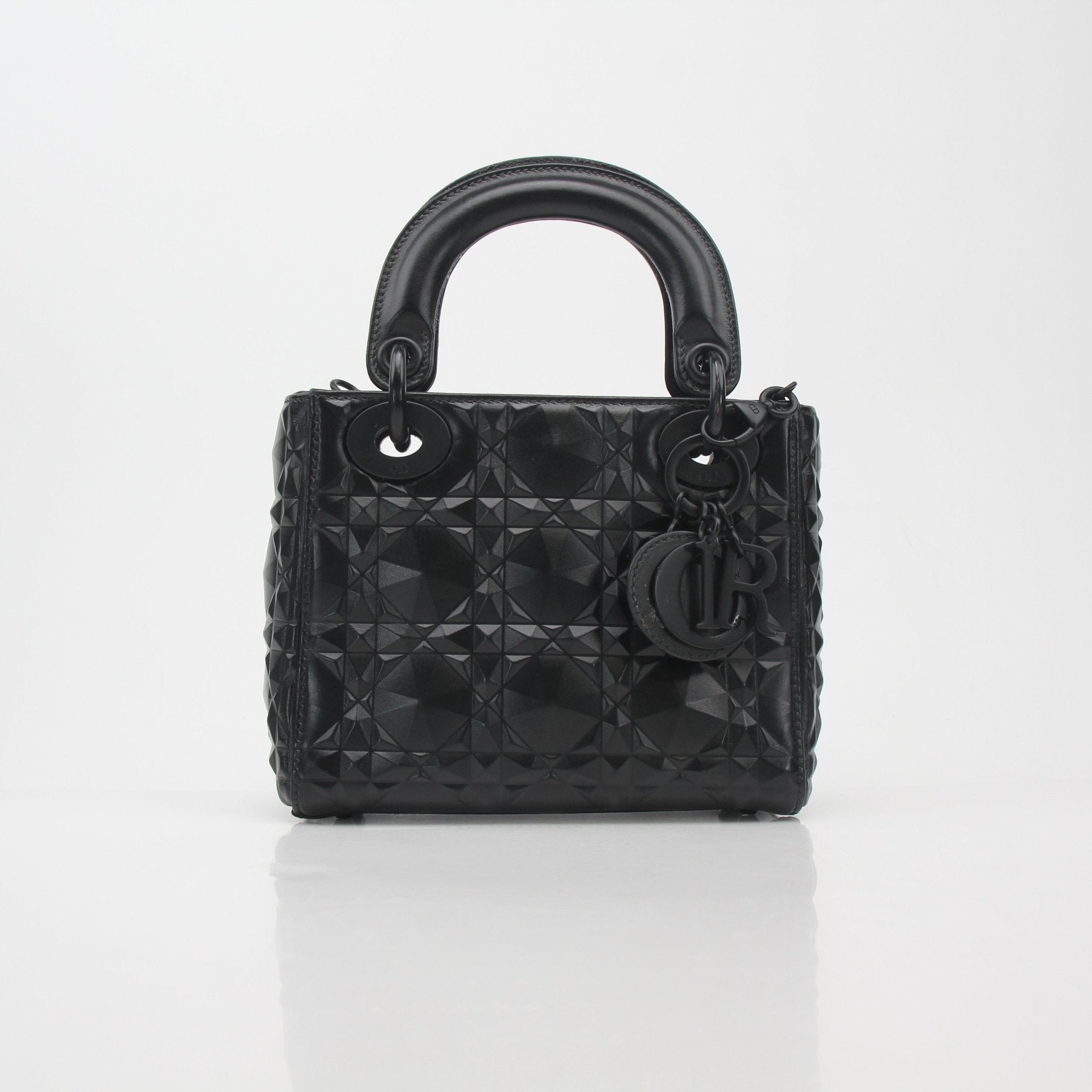 Black Christian Dior Mini Lady Dior tote bag with gold hardware, featuring signature quilting and top handles.