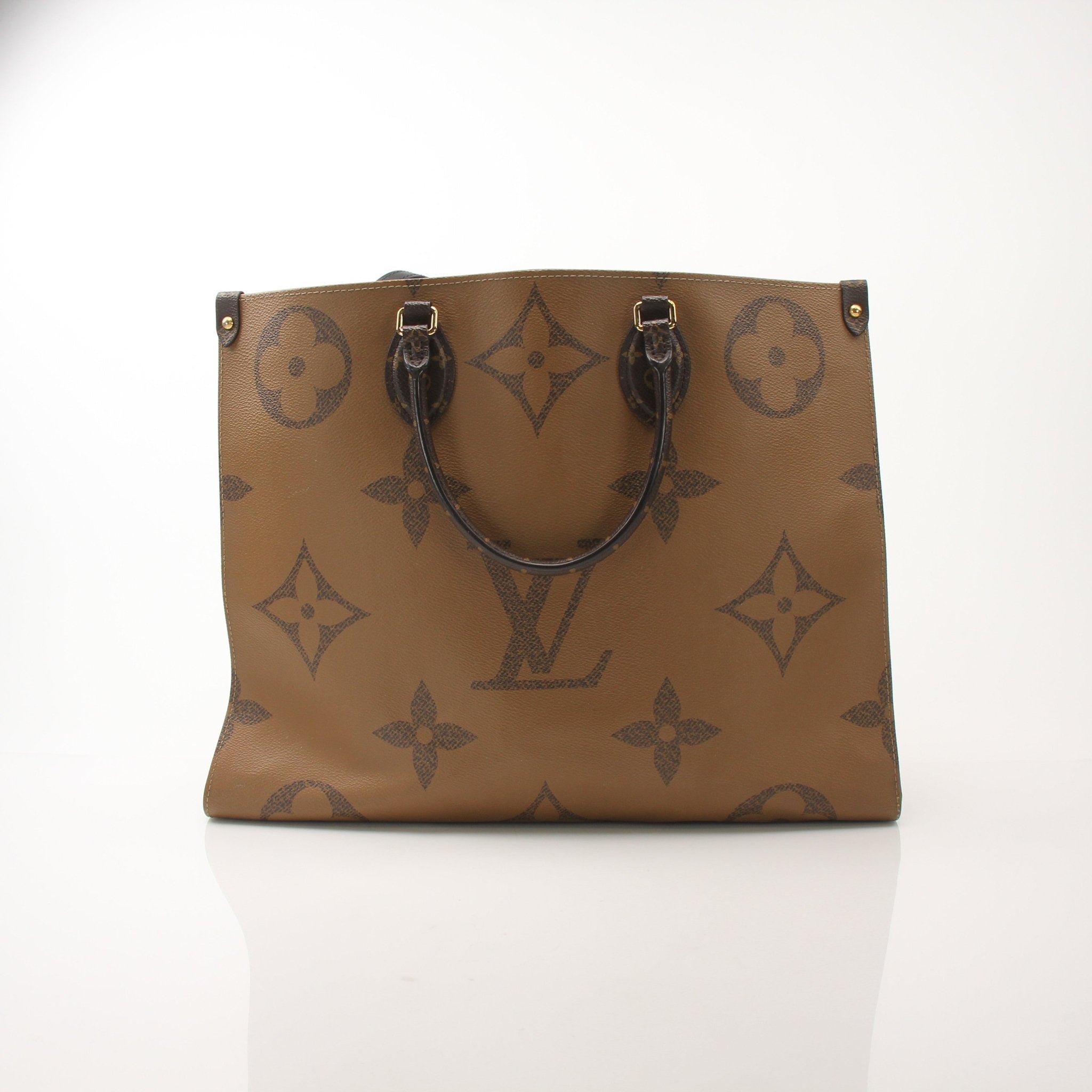 Louis Vuitton OnTheGo Reverse MM handbag with gold-tone hardware and large leather handles, showing the bag's front view.