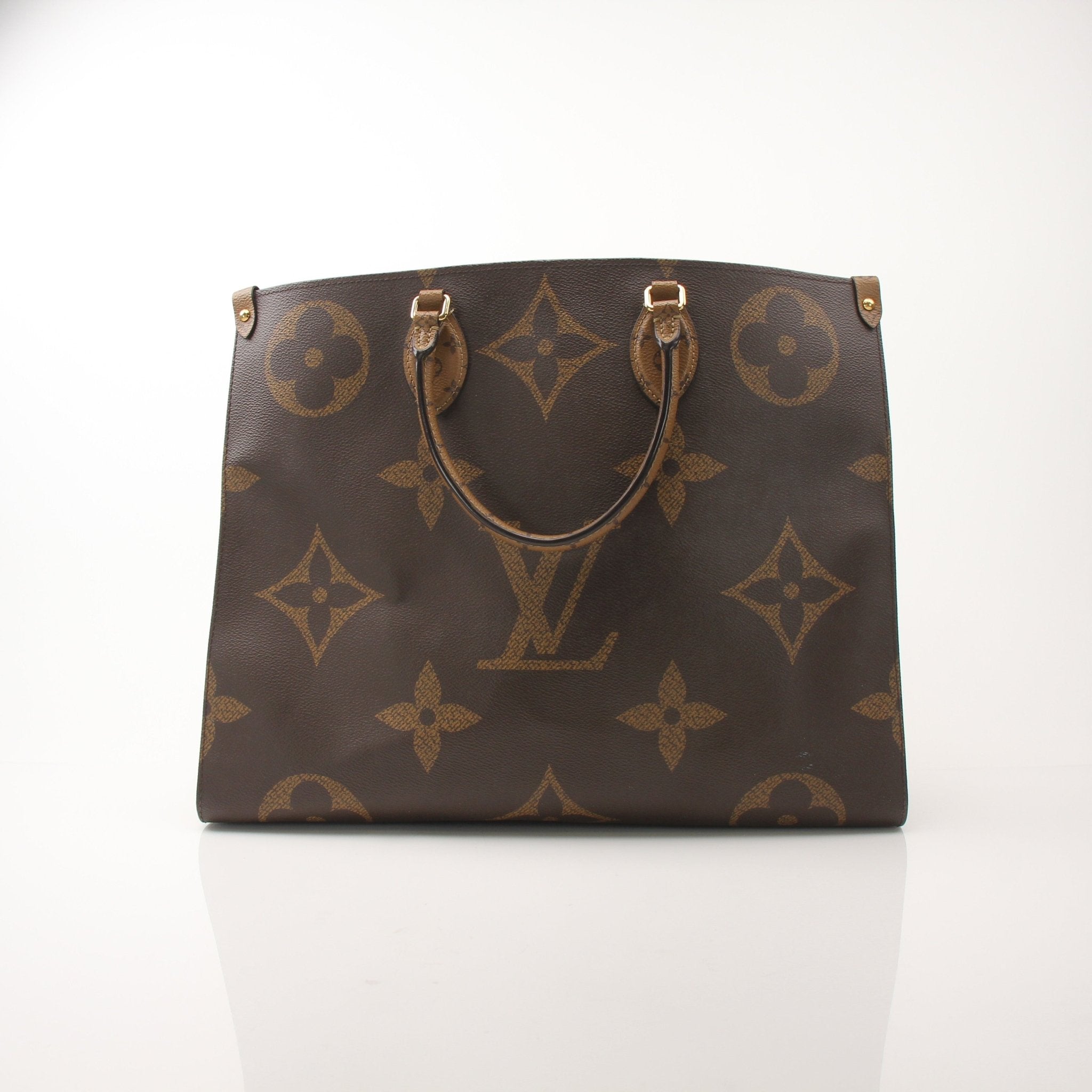 Louis Vuitton OnTheGo Reverse MM handbag in monogram canvas with gold-tone hardware and leather handles.