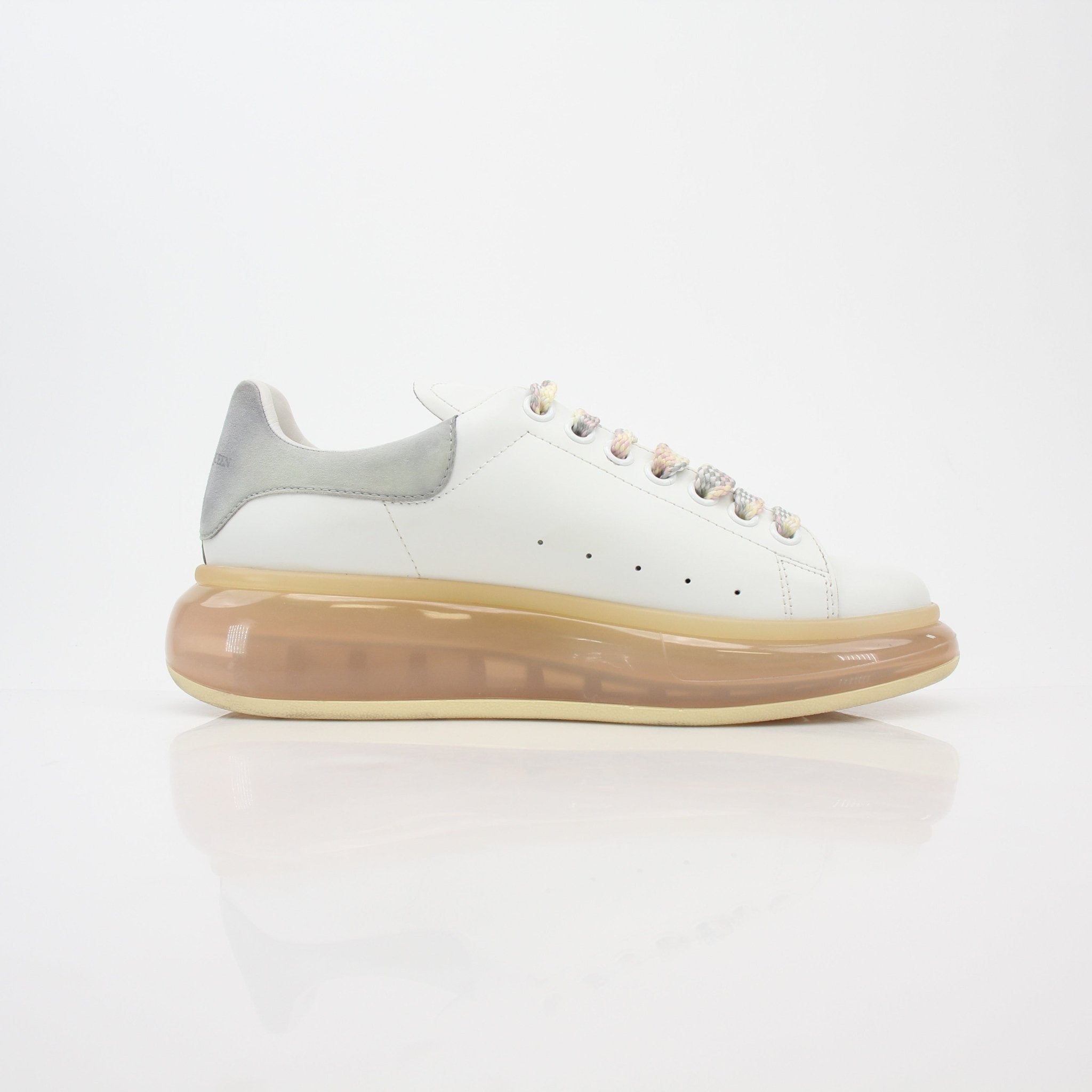 Alexander McQueen white oversized transparent-sole sneakers with sleek design and clear rubber soles, showcasing modern, fashionable footwear.