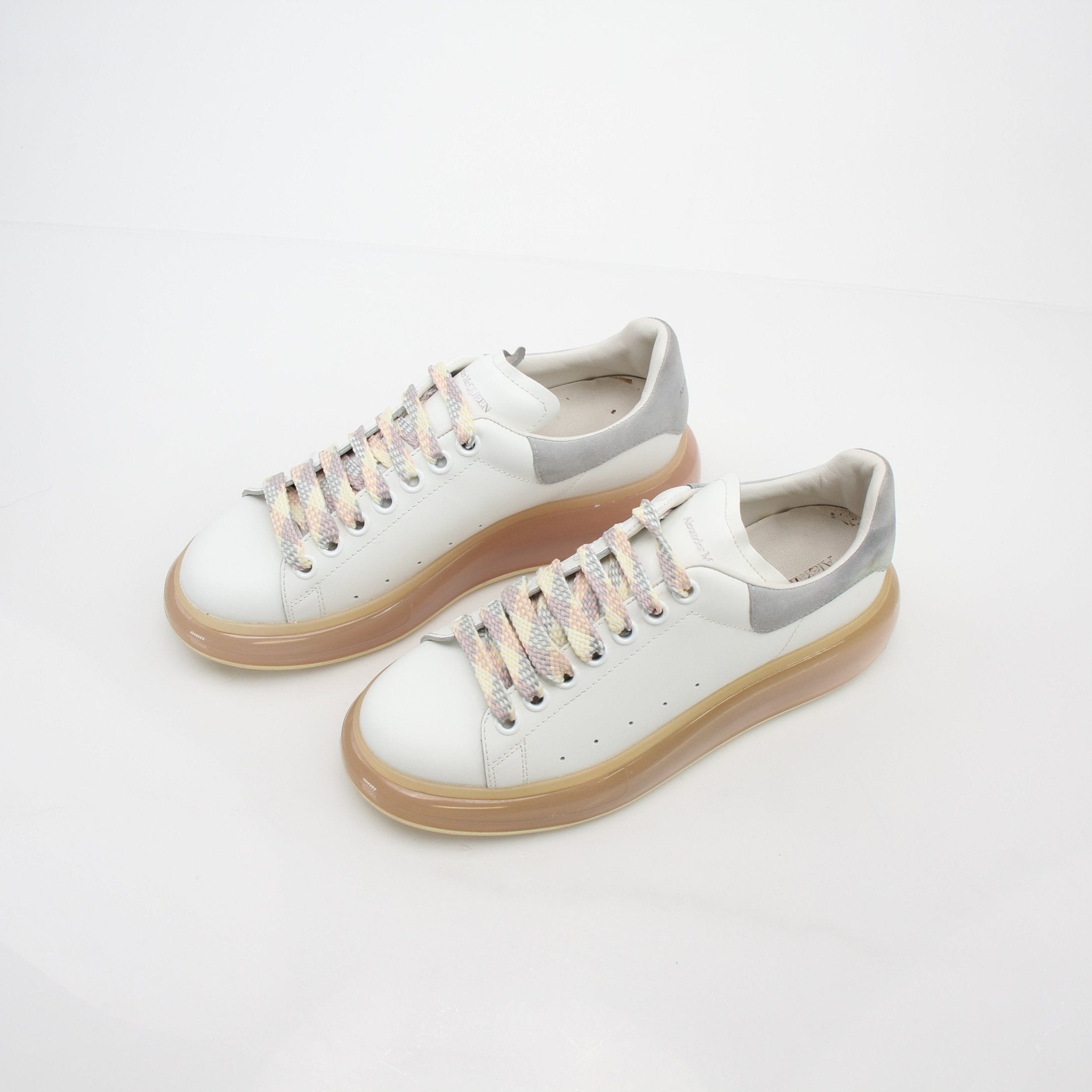 Alexander McQueen white oversized transparent-sole sneakers with chunky design and silver accents, displayed on a plain background.