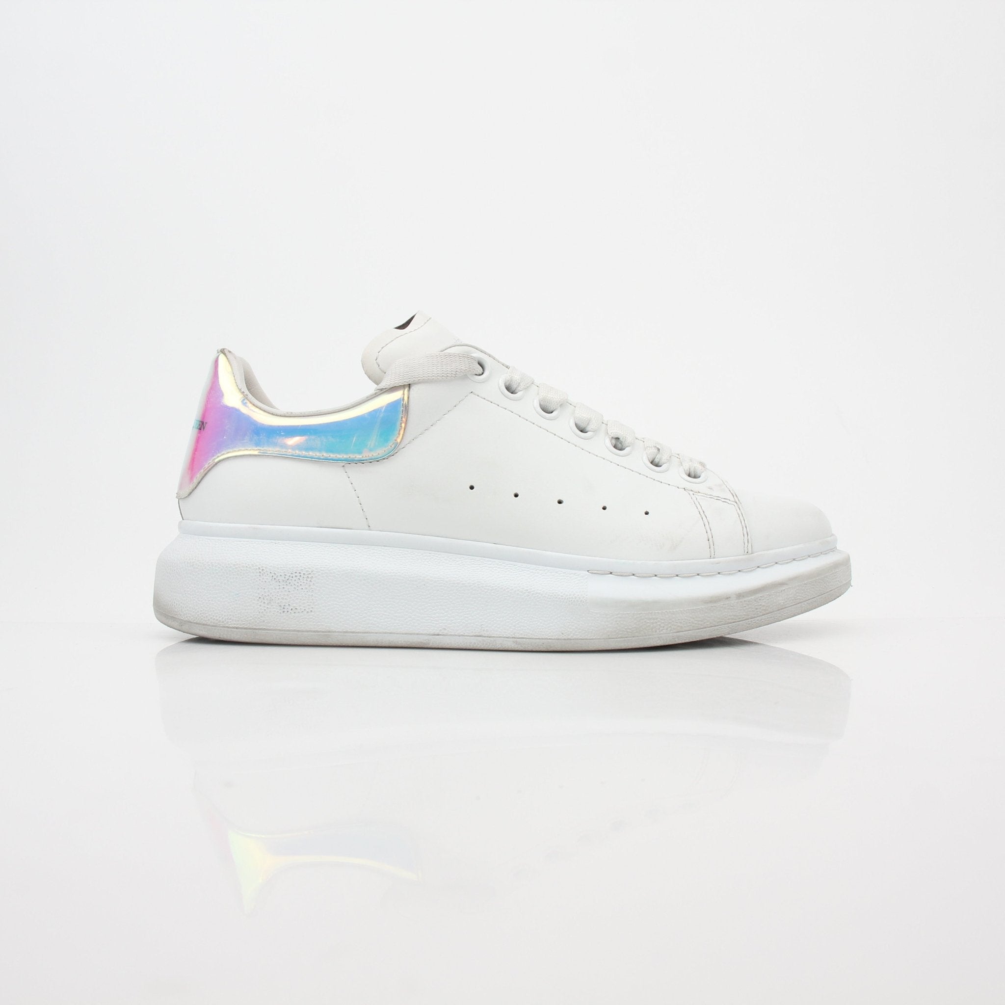 White Alexander McQueen oversized sneakers with iridescent heel detail, showcasing a chunky shoe design and modern style.