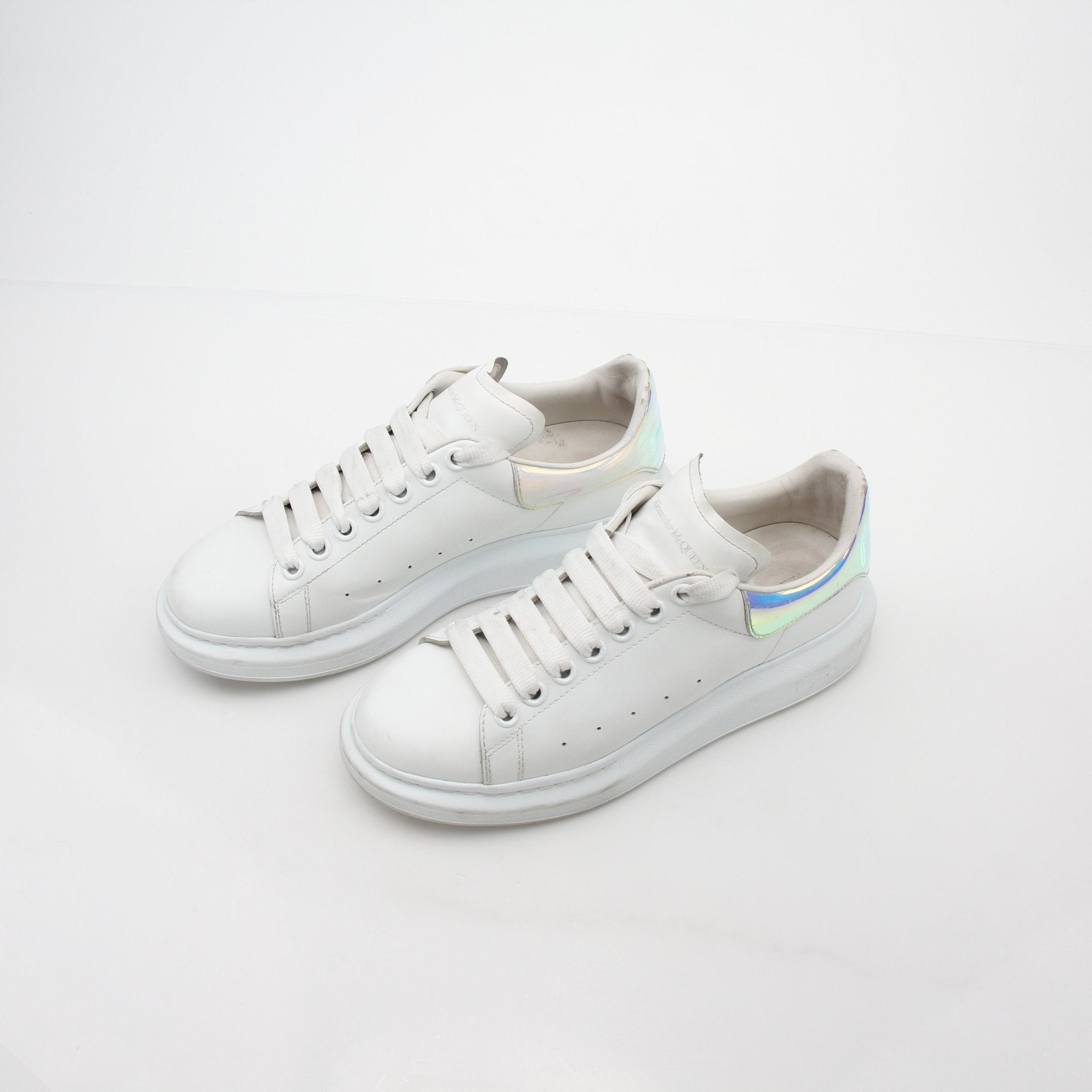 Alexander McQueen white oversized sneakers with iridescent heels, showcasing a trendy, chunky shoe design with bold style details.