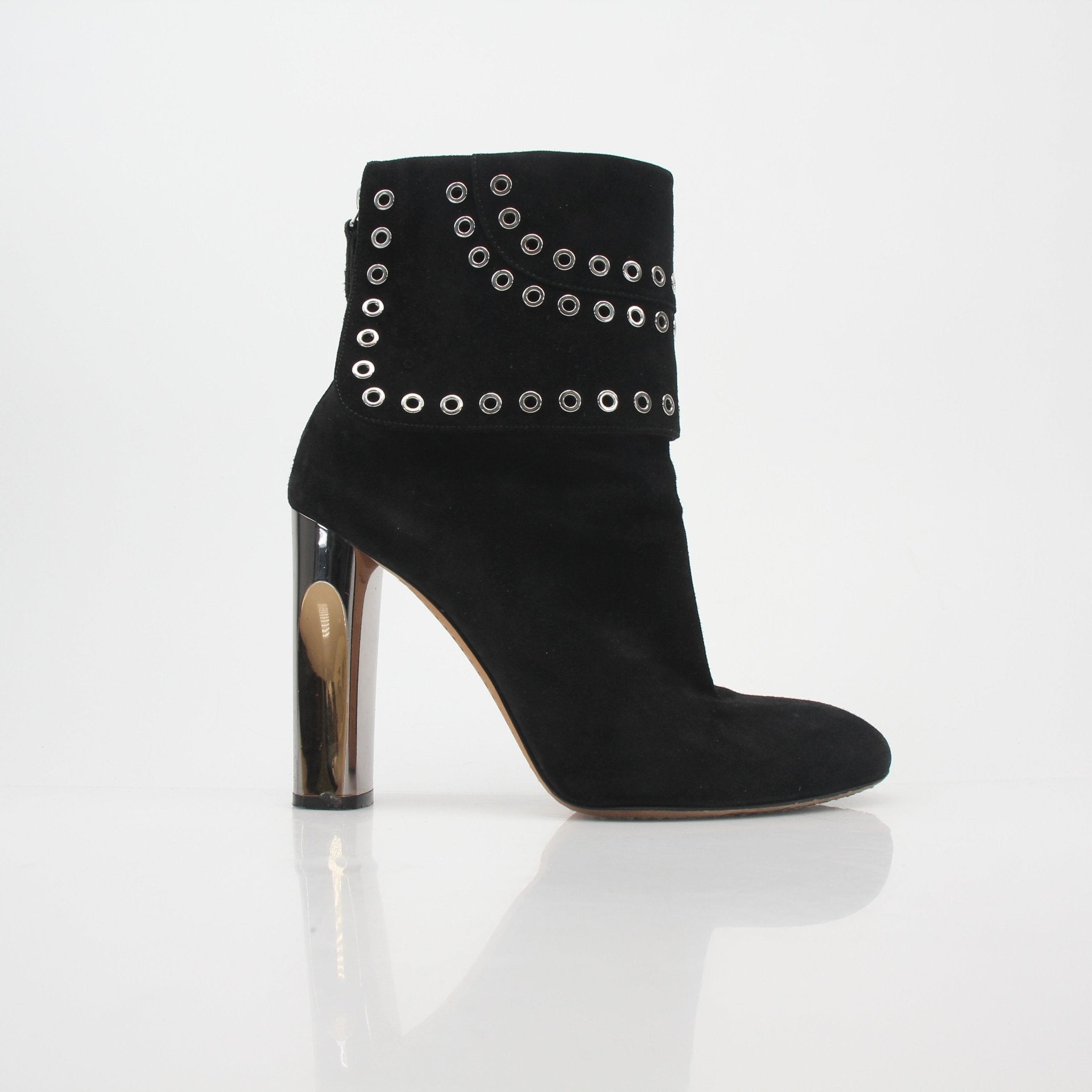 Black Alexander McQueen grommet fold-over ankle boots with chunky soles and metal eyelet details, displayed on a neutral background.